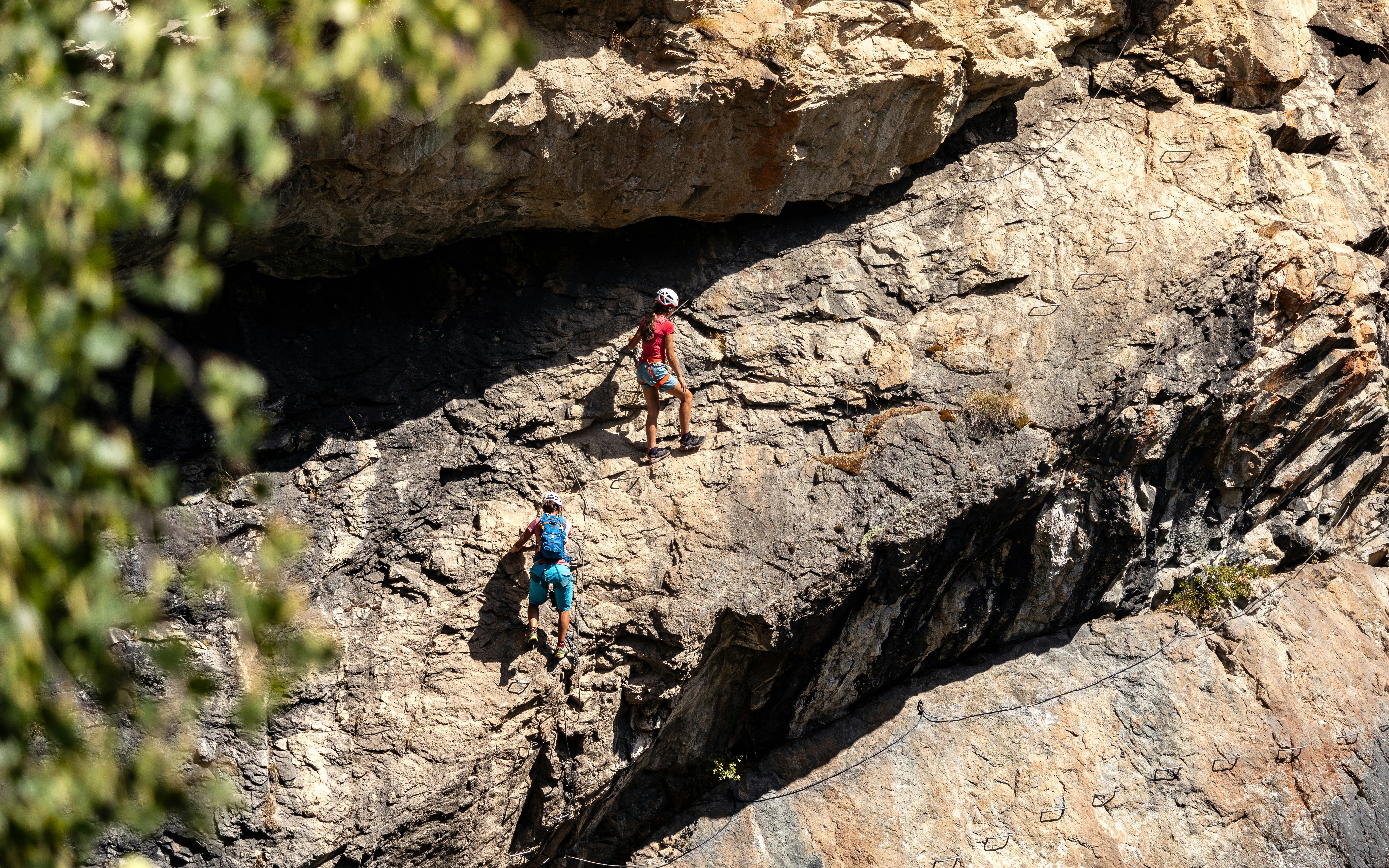 A group of people climbing up the side of a mountain, "On the Wall"