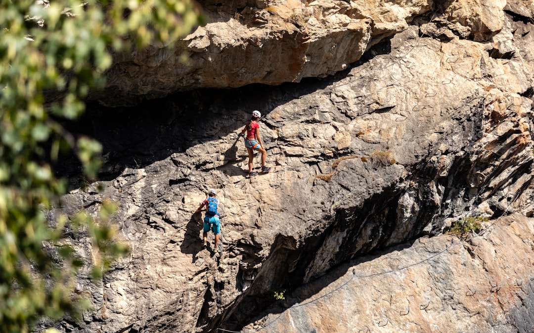 A group of people climbing up the side of a mountain,
