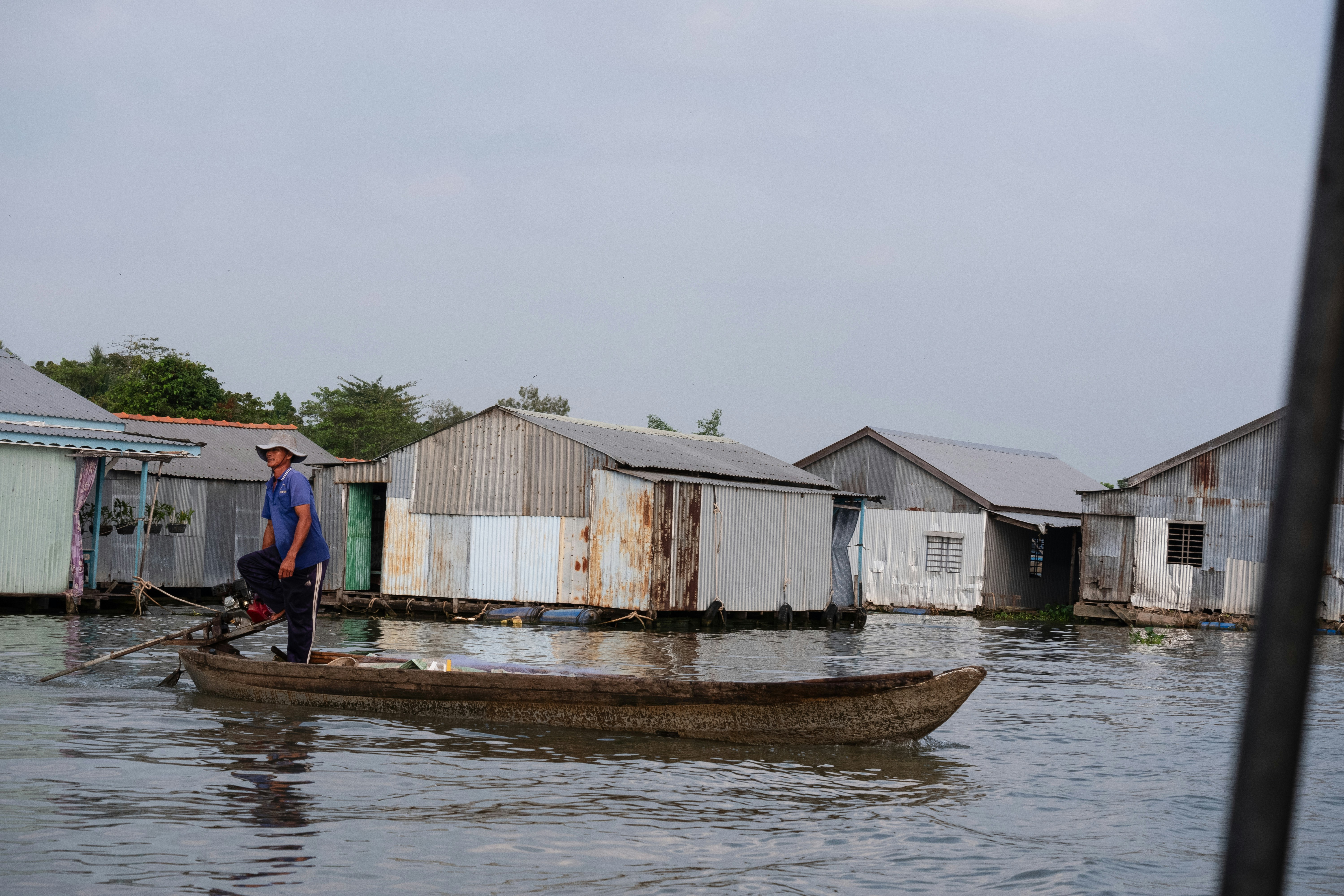 A man standing on a boat in a flooded area