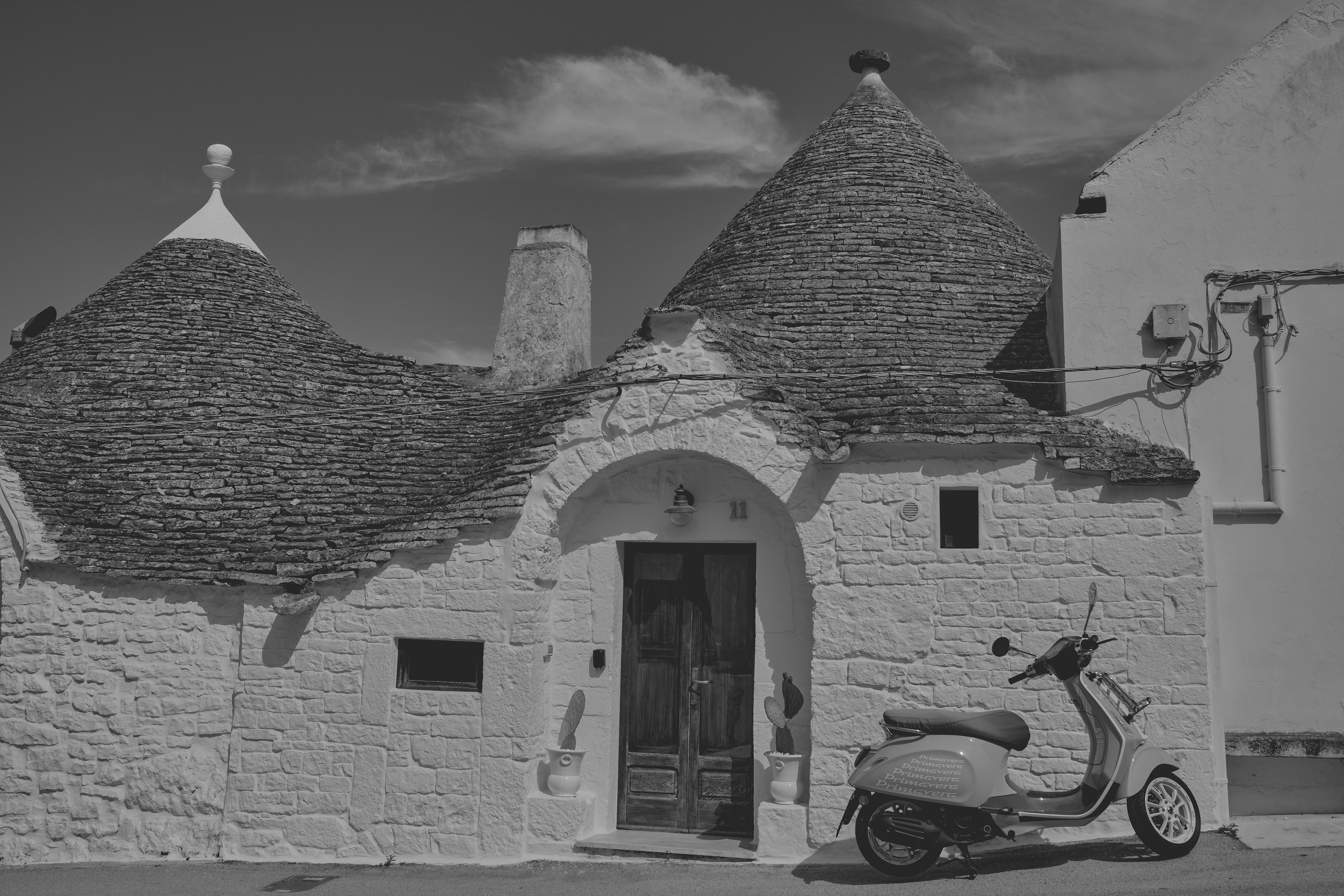 A scooter parked in front of a white building