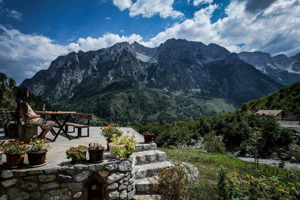 A scenic view of a mountain range with a picnic table in the foreground