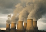 A group of smoke stacks emitting from a factory