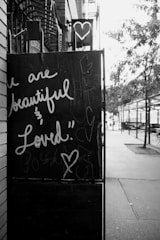 A black and white photo of a sign on the side of a building