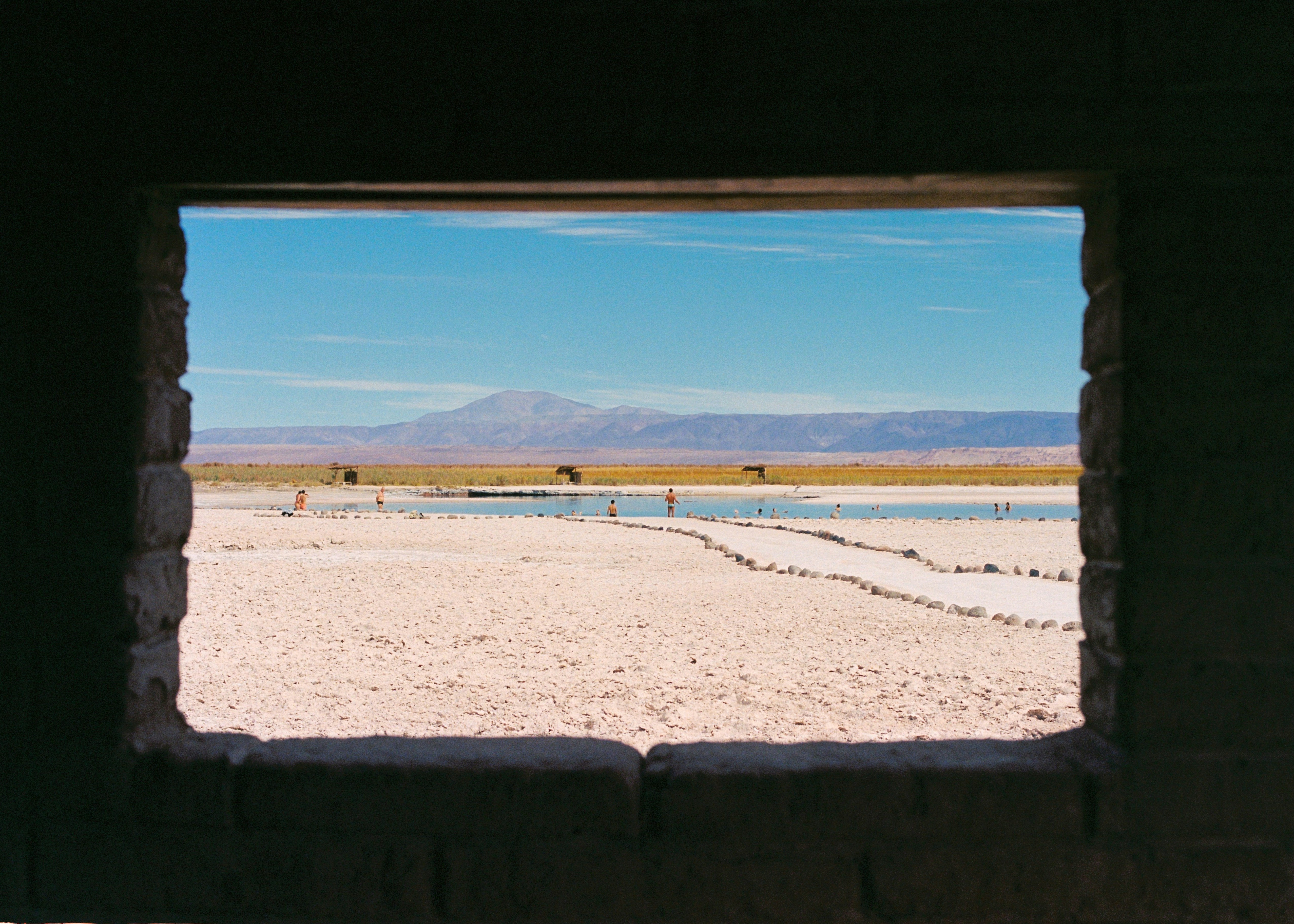A window in a wall looking out onto a desert photo – Free Summer Image ...