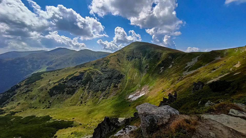 Breathtaking mountain landscape features a green valley between two towering mountains in the distance