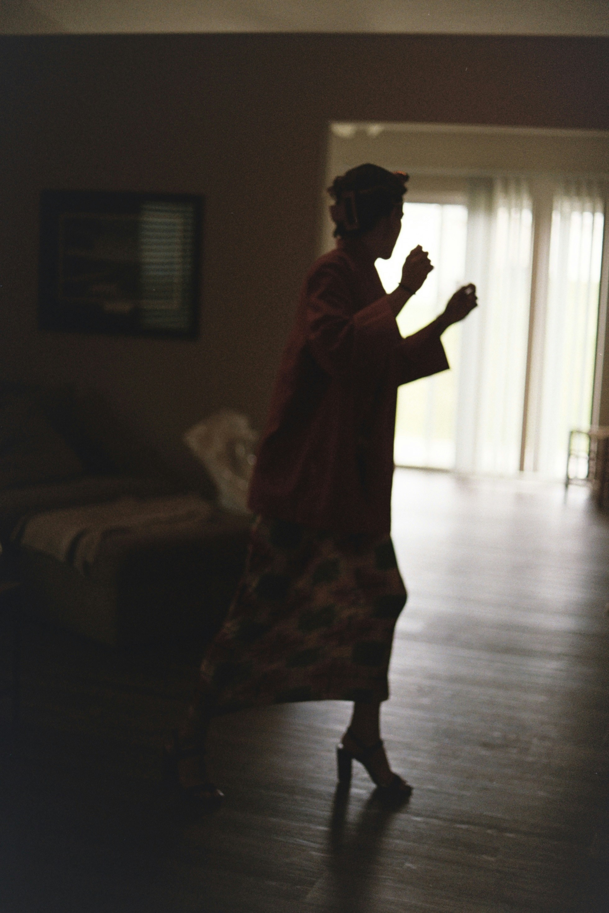 A woman standing in a living room next to a couch