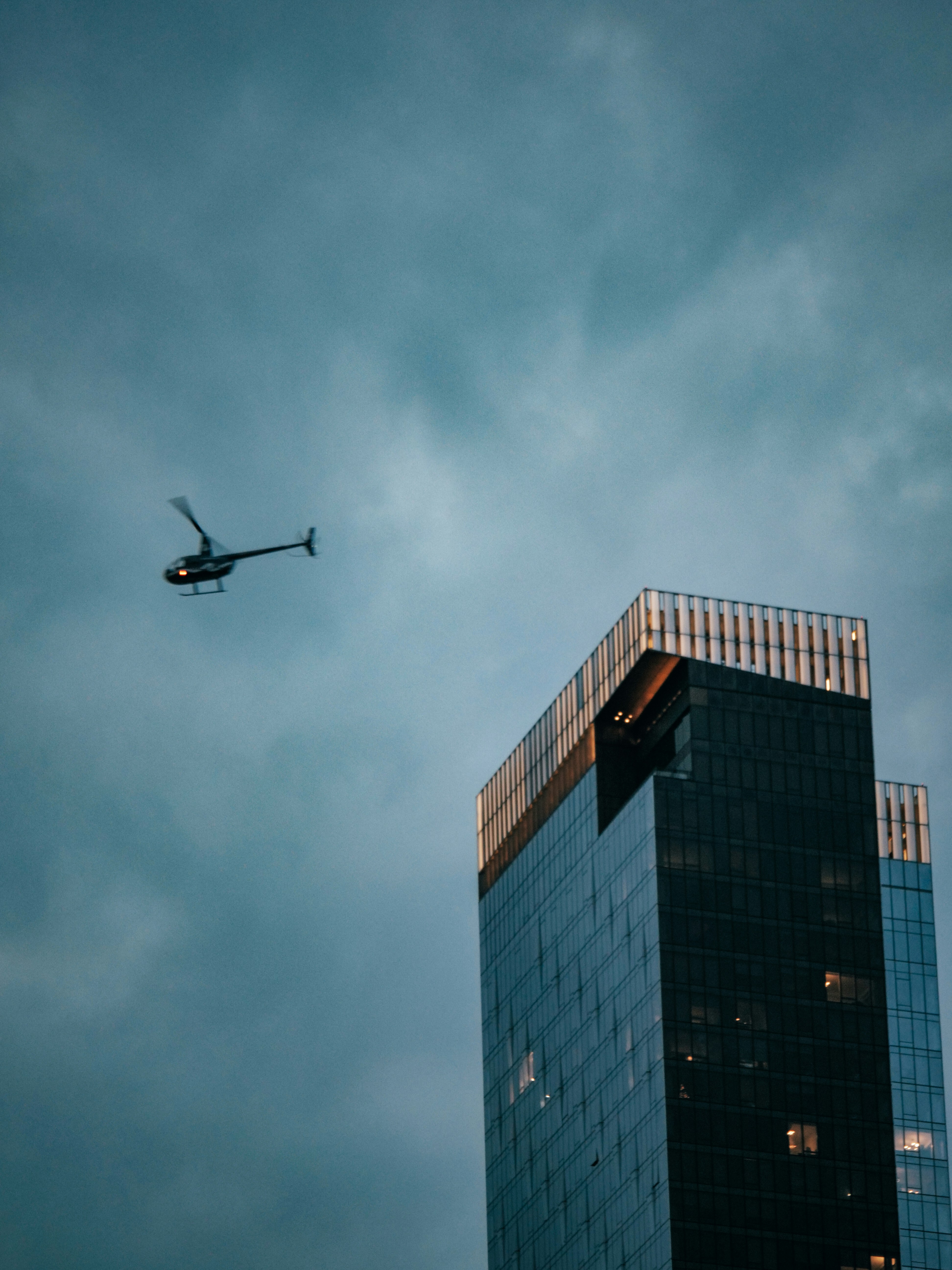 A helicopter flying in the sky over a tall building