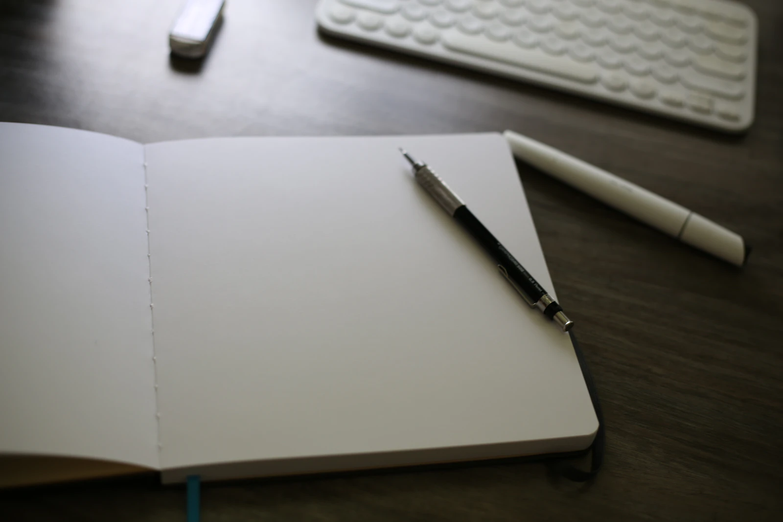 An open notebook on a desk next to a keyboard