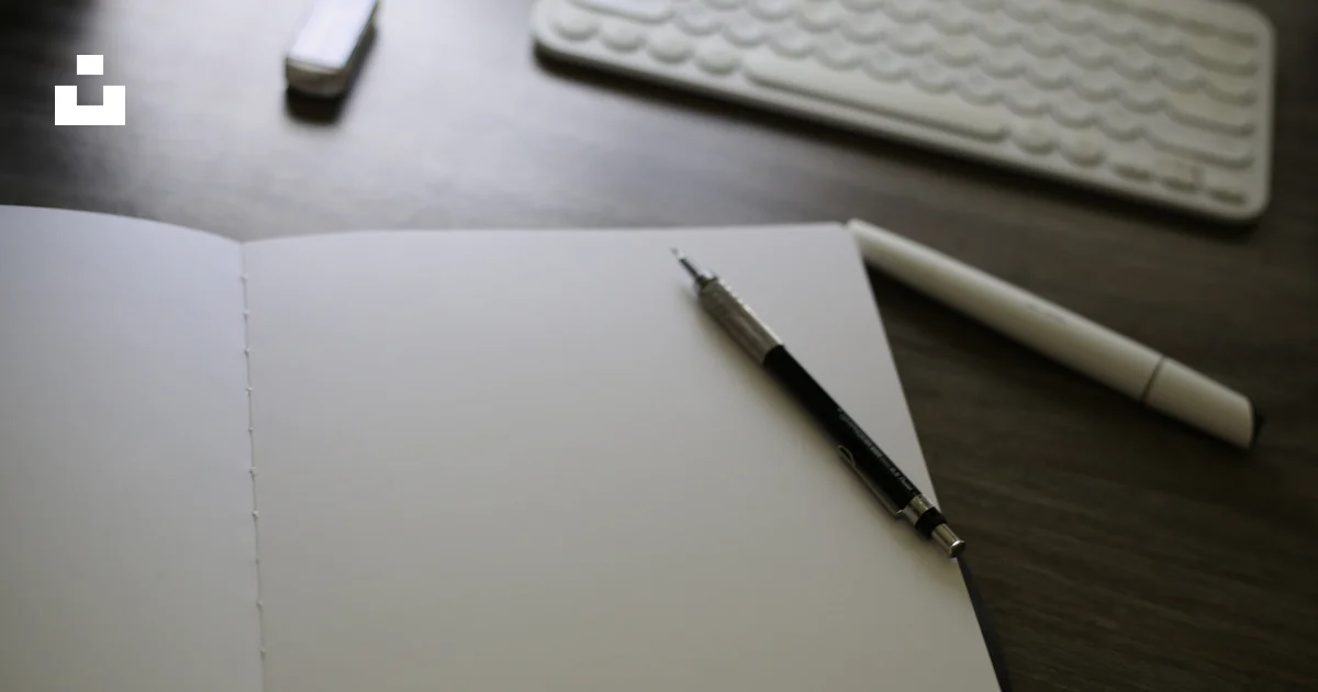 An open notebook sitting on top of a desk next to a keyboard photo ...