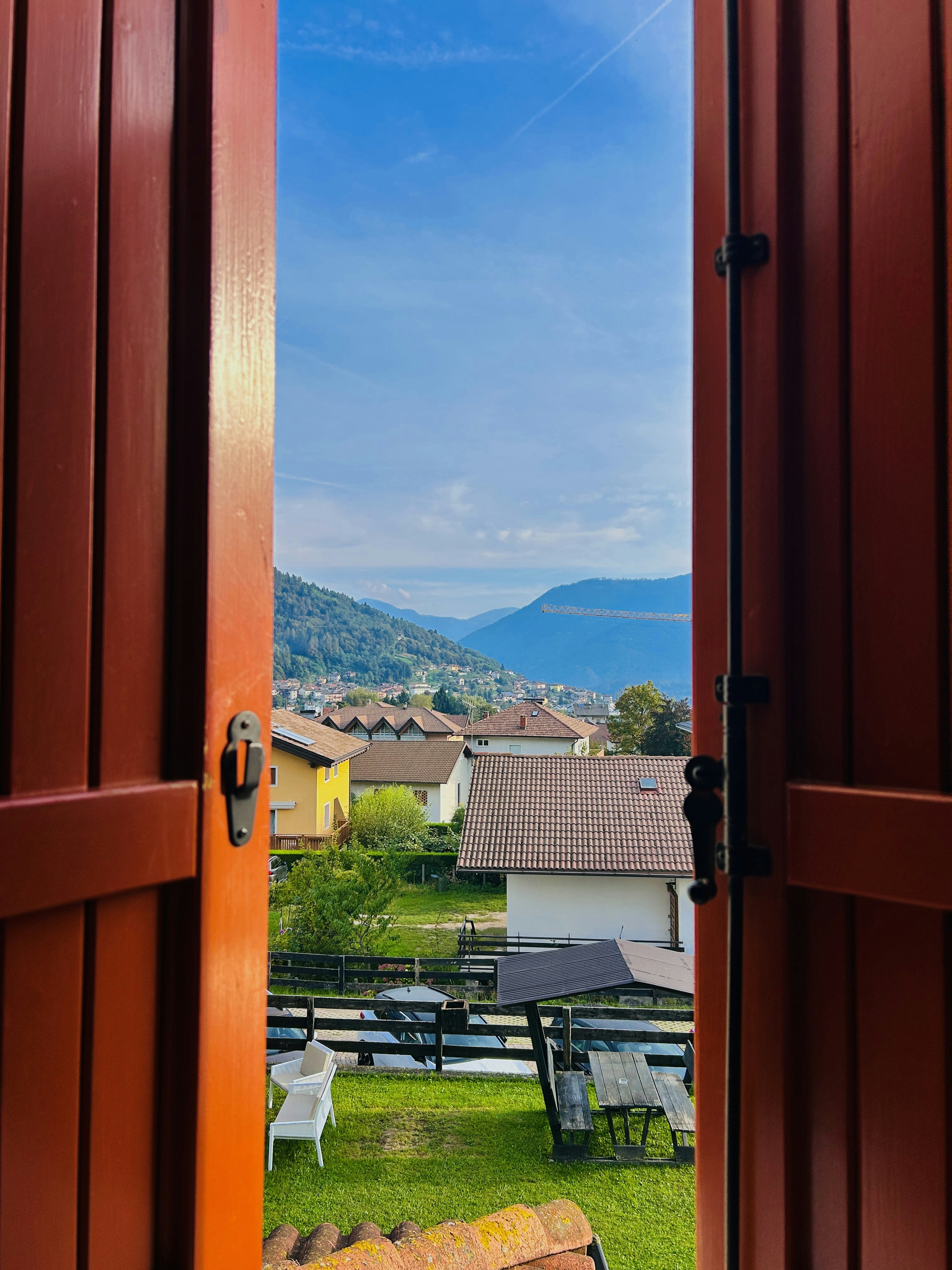 An open door leading to a patio with a view of the mountains