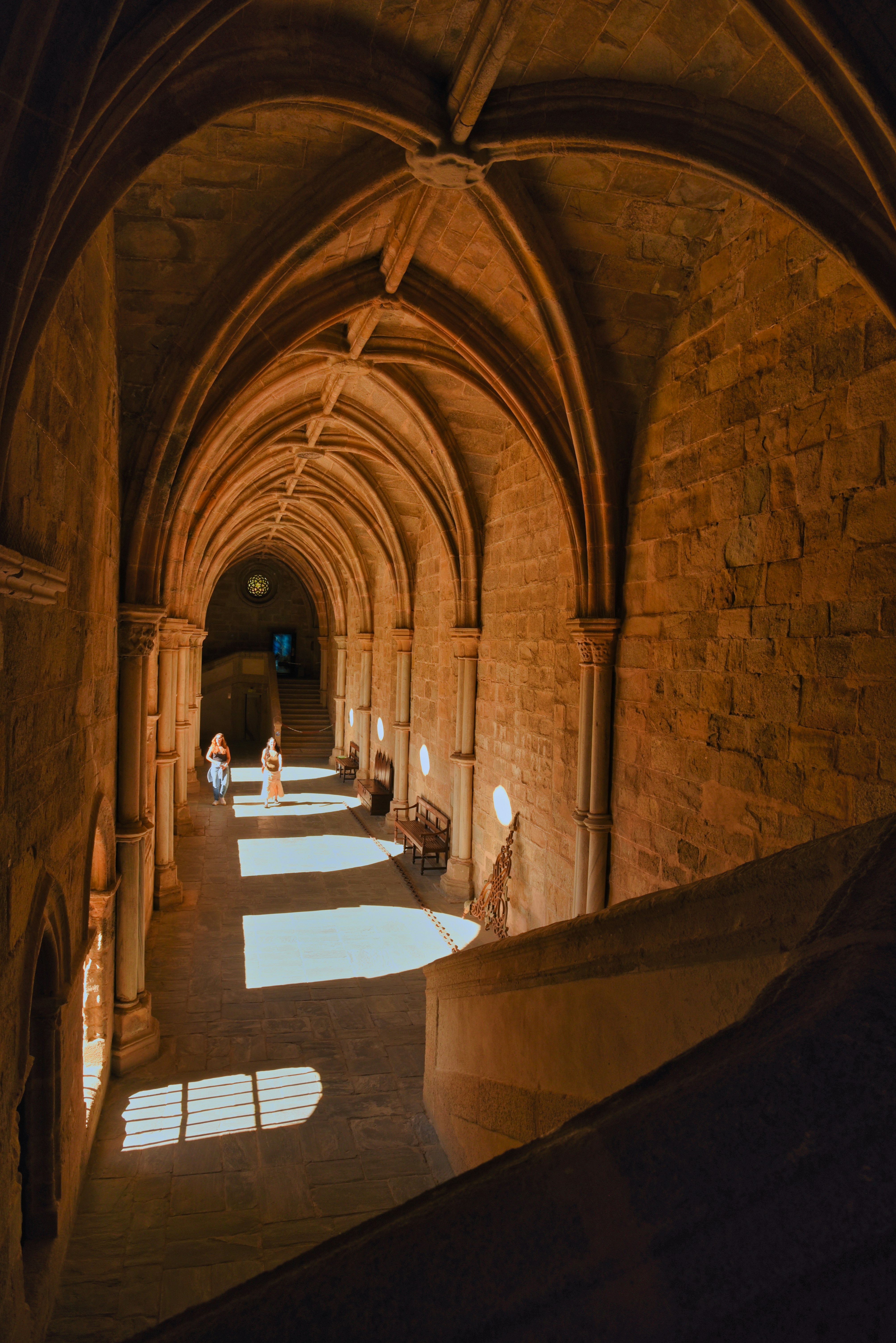 A long hallway in a building with stone walls and arches