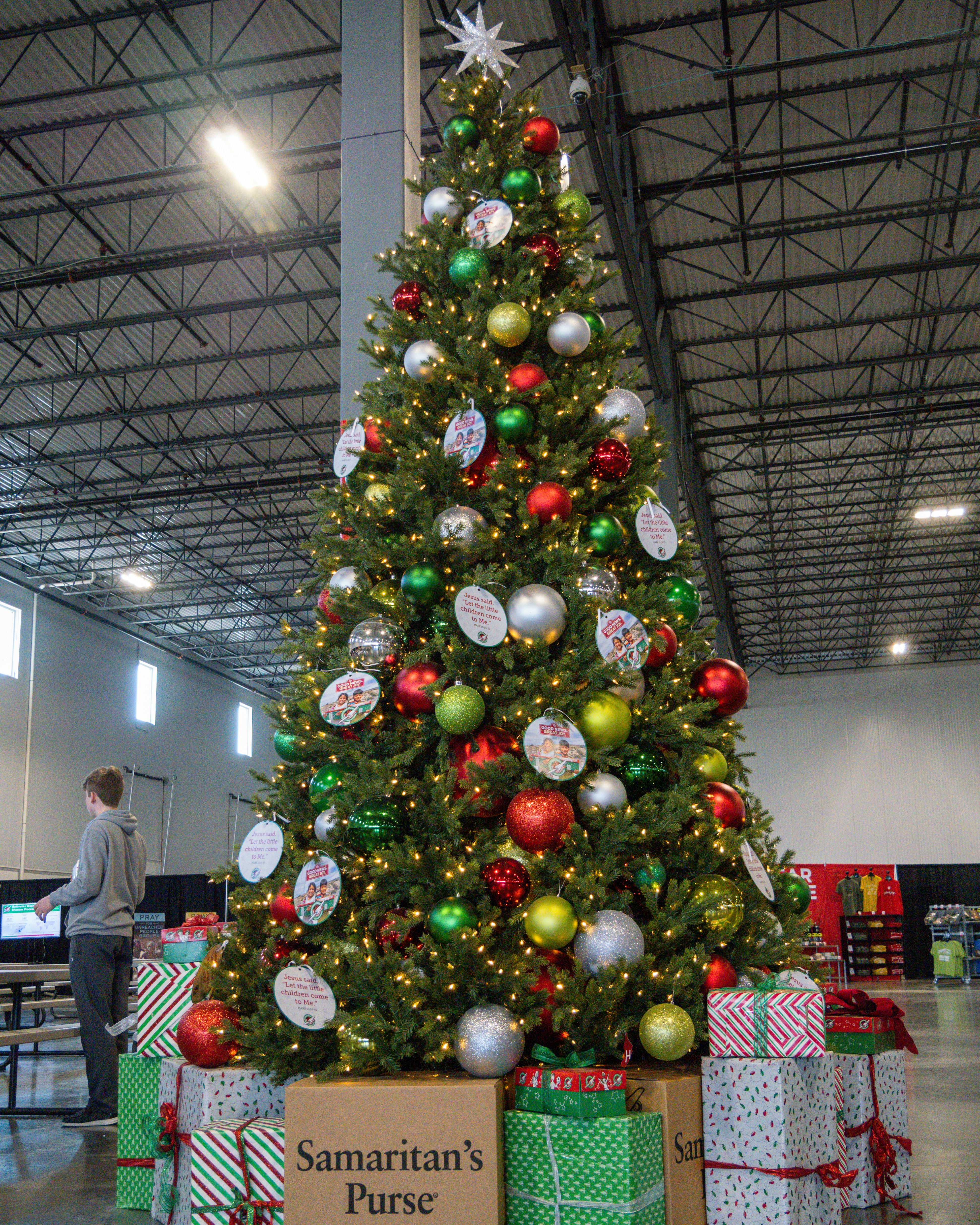 A christmas tree with presents under it in a warehouse