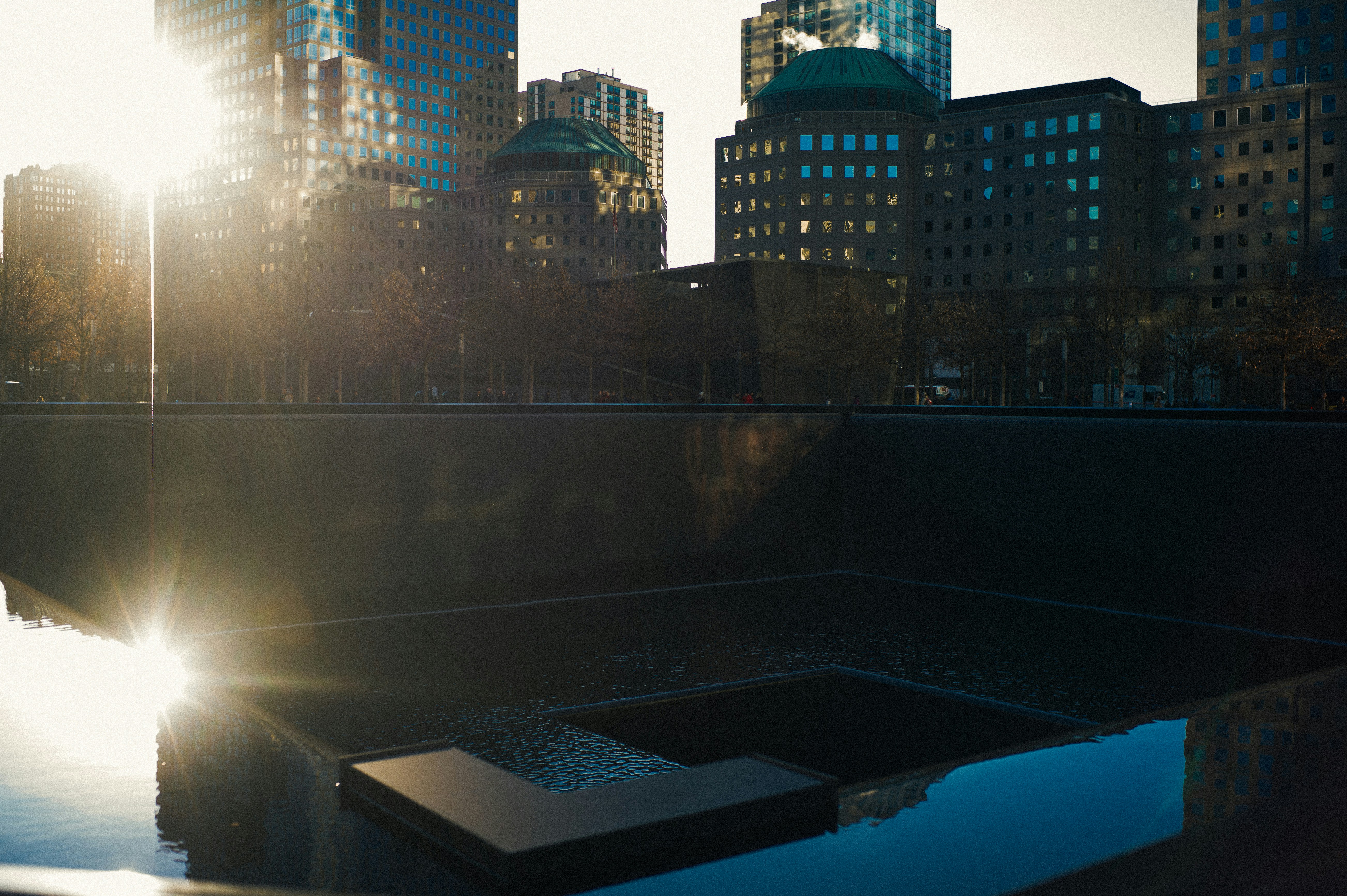 The sun shines brightly over the skyline of a city