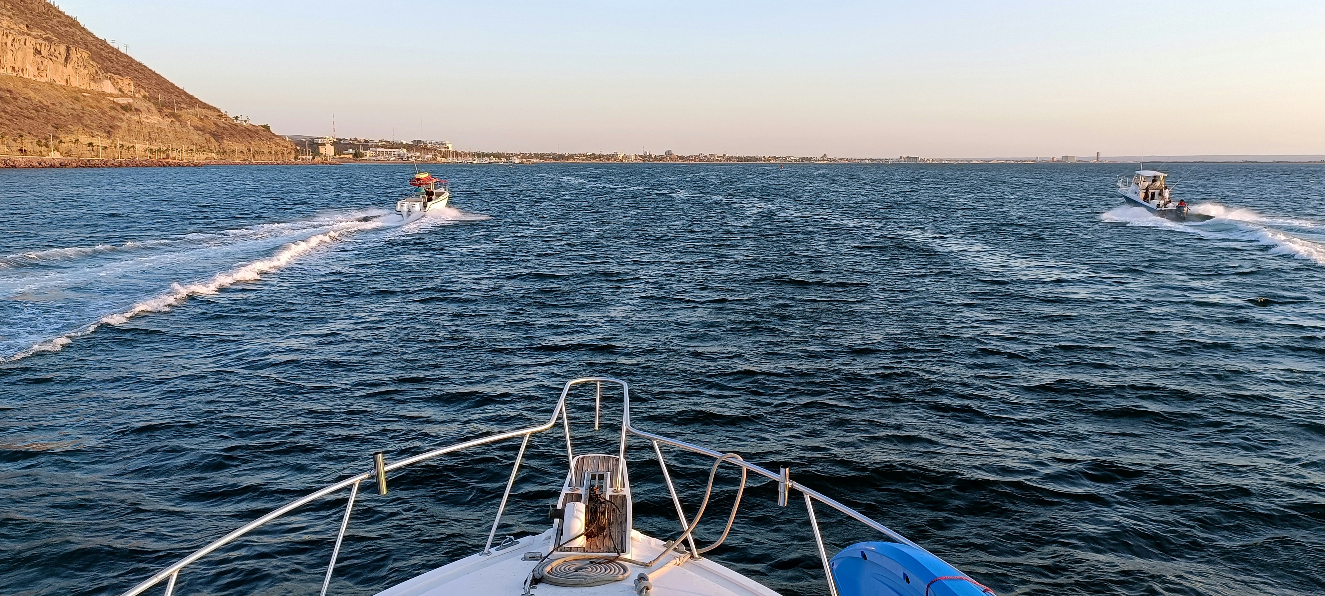 A couple of boats traveling across a large body of water