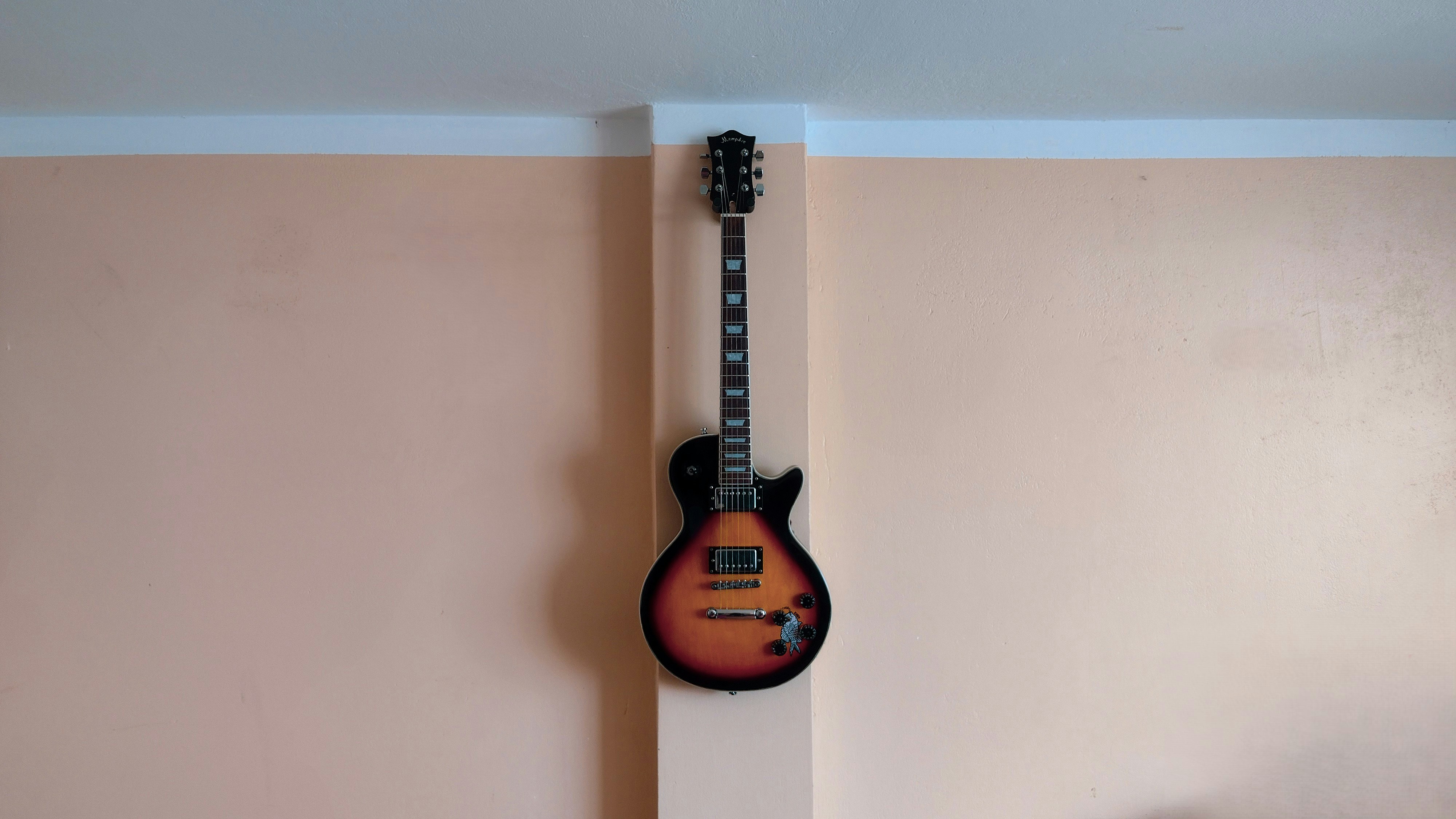 A guitar hanging on a wall in a room