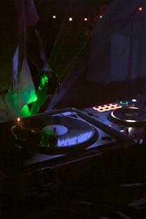 A dj mixing music in a tent at night