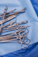 A pile of surgical scissors on a blue cloth