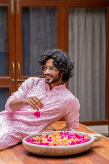 A man sitting on a table with a bowl of flowers