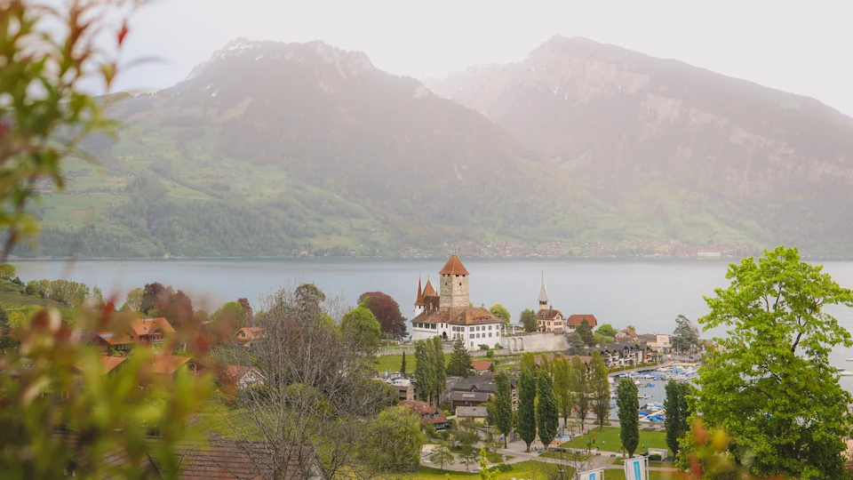 Mountain range with picturesque town and lush greenery at its base, surrounded water