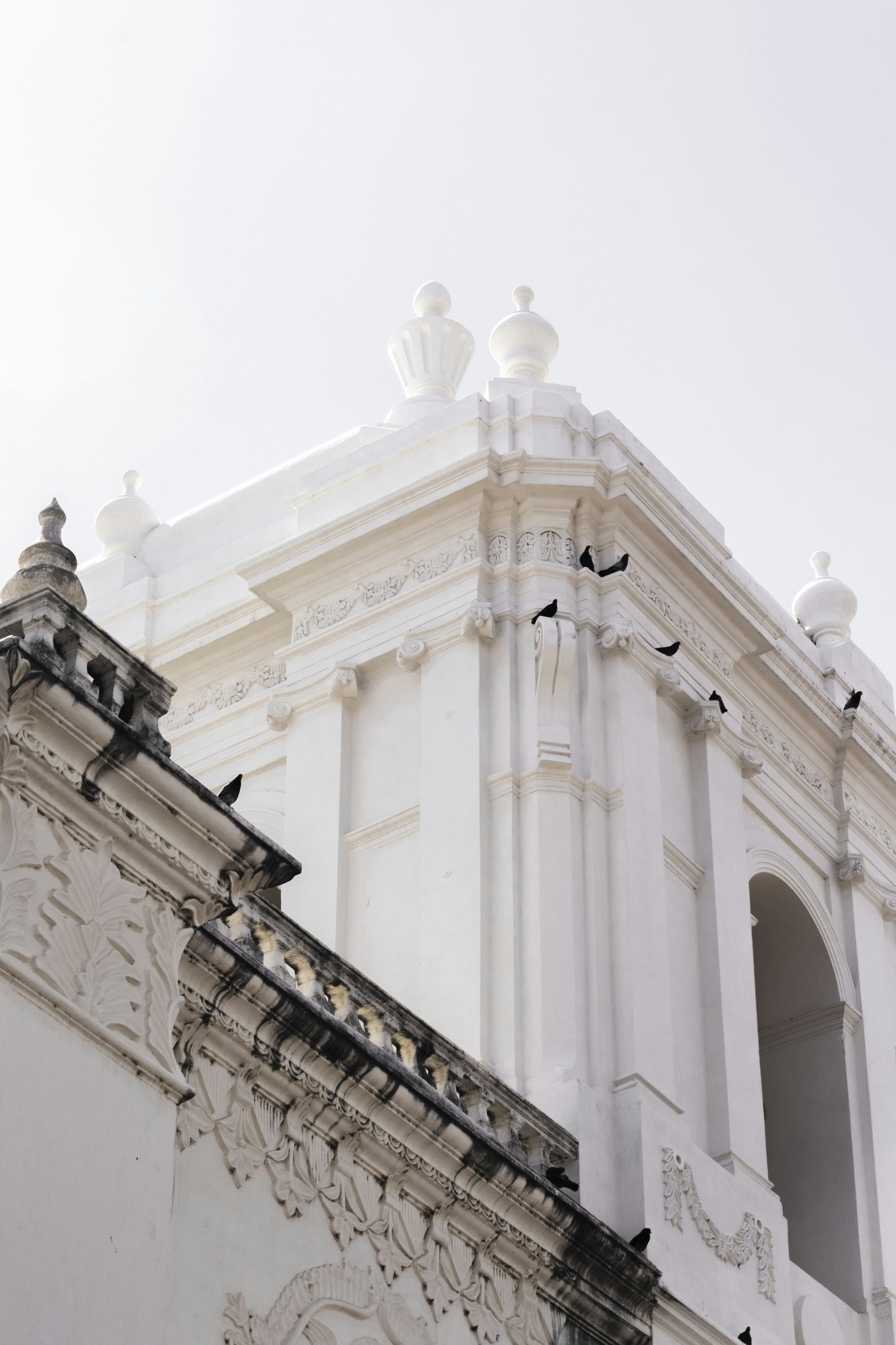 Un grand bâtiment blanc avec une horloge sur le côté