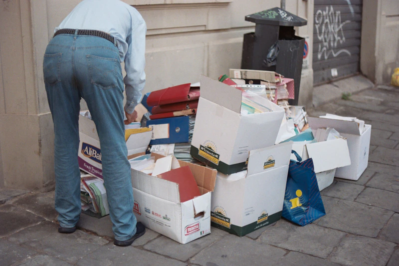 uomo accanto a pile di scatole