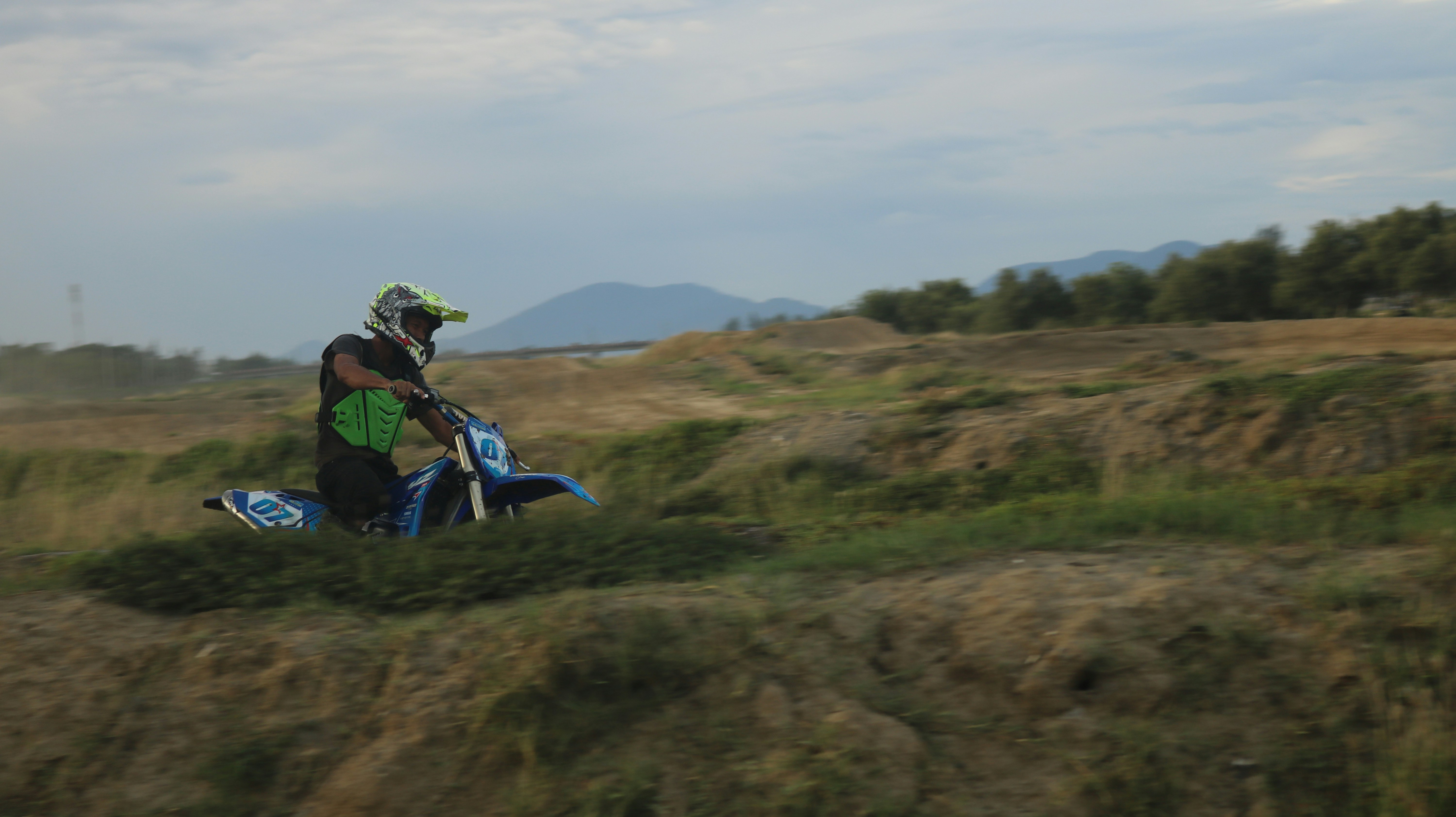 A man riding a motorcycle on top of a lush green field