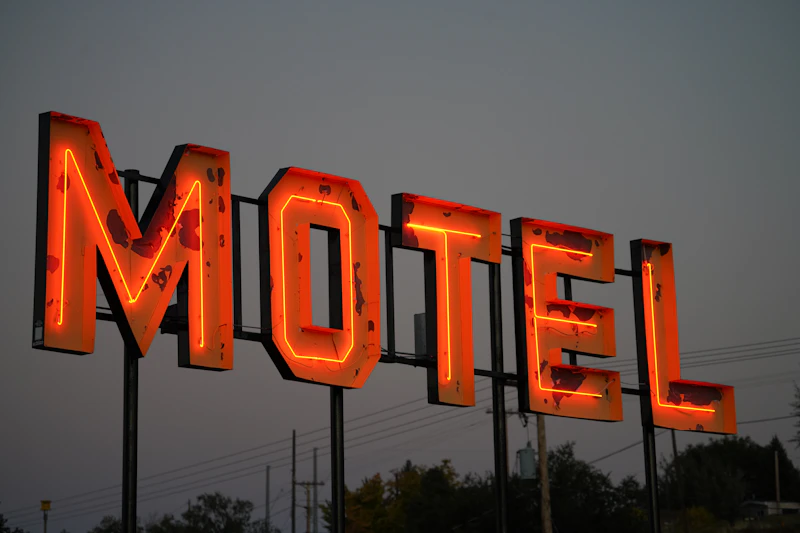 Weathered neon MOTEL sign lit at dusk