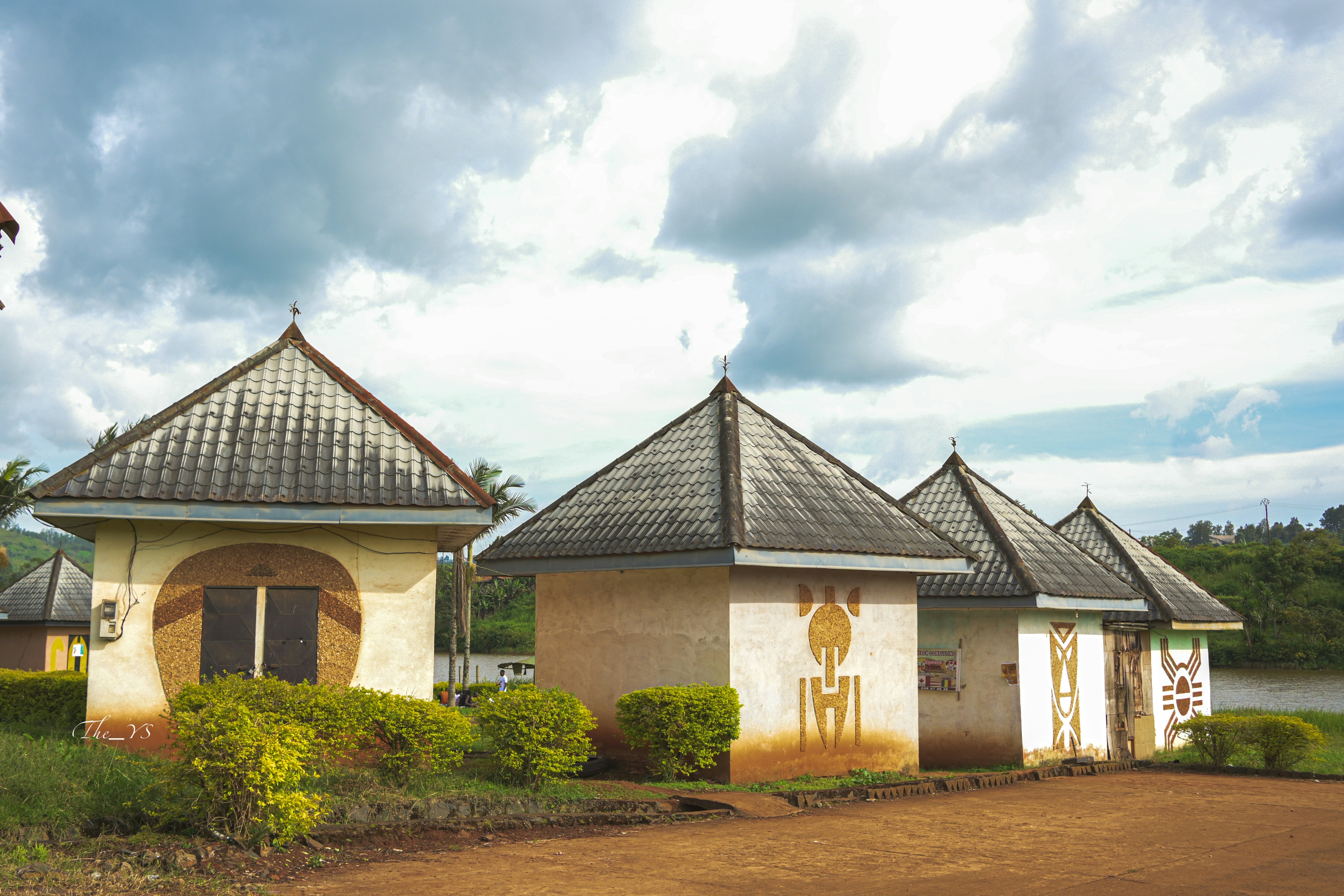 A couple of houses sitting on top of a lush green field