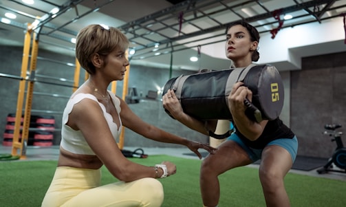 A man and a woman doing squats in a gym