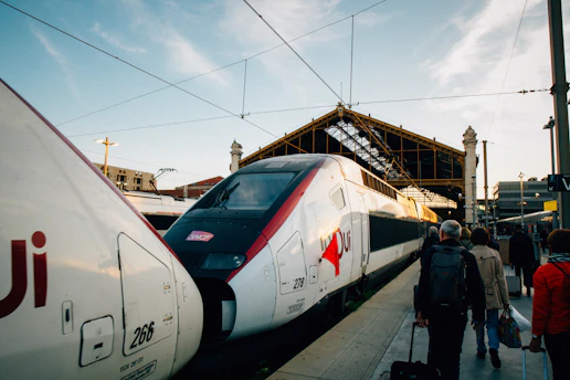 A group of people standing next to a train