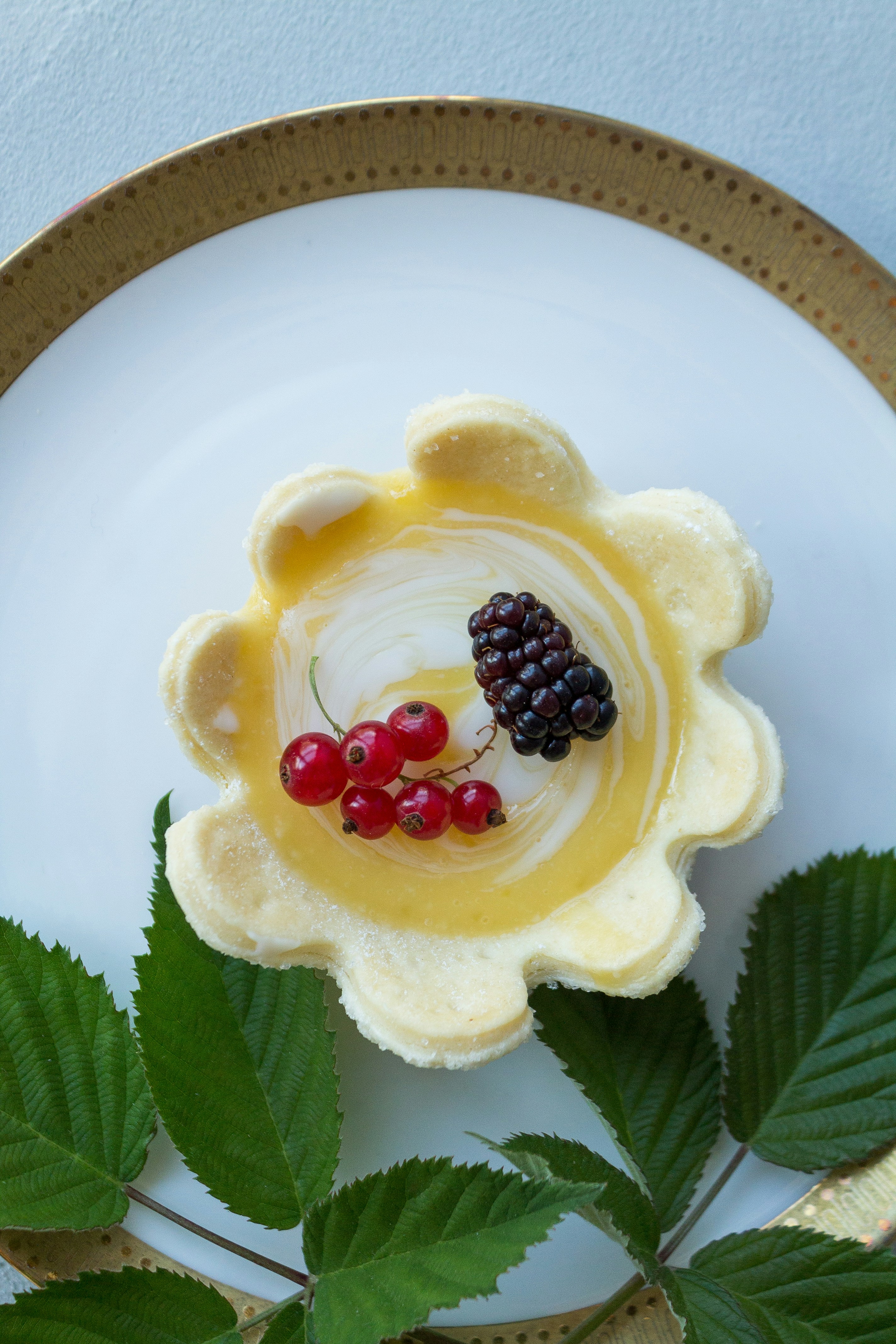 A white plate topped with a yellow flower and berries