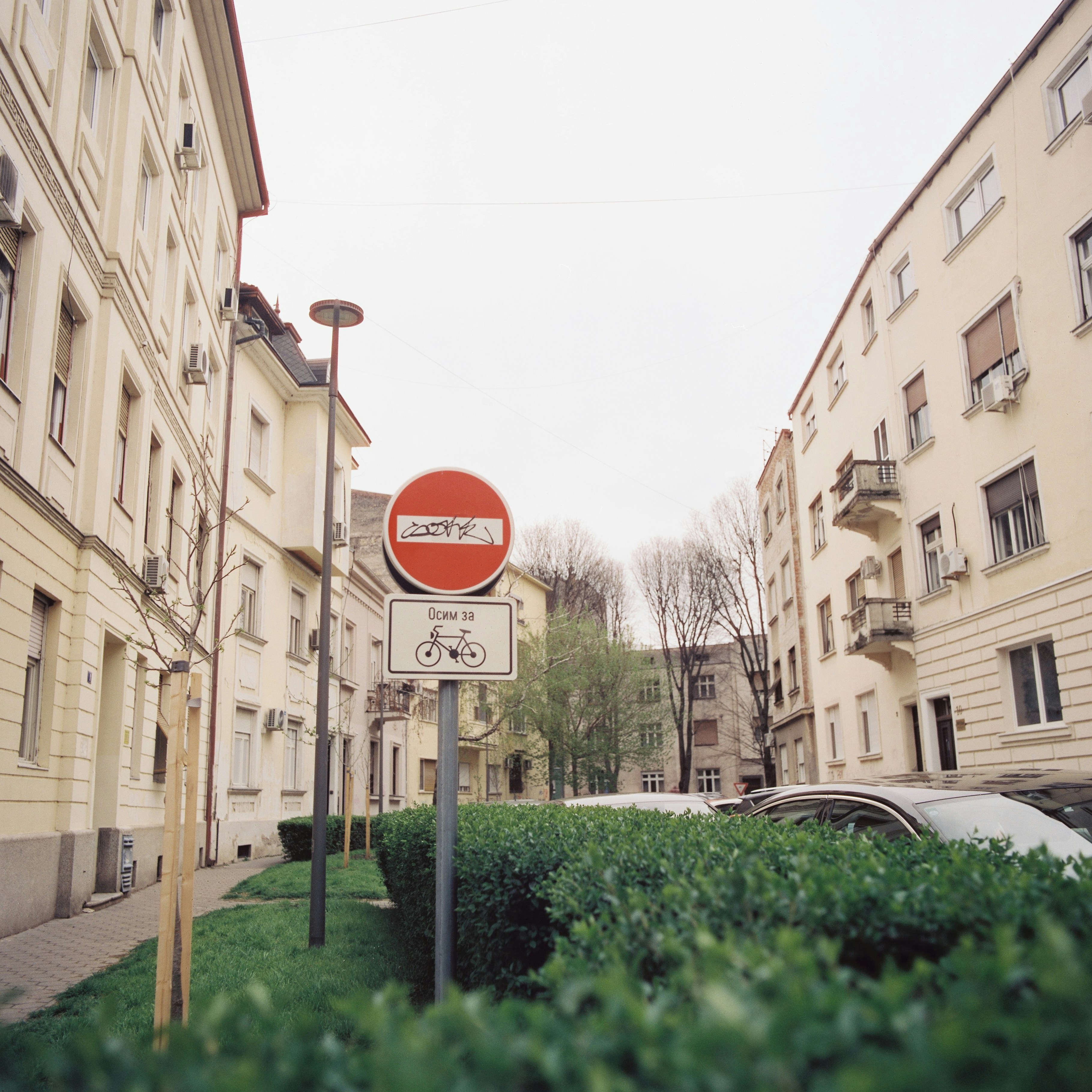 A red street sign sitting on the side of a road