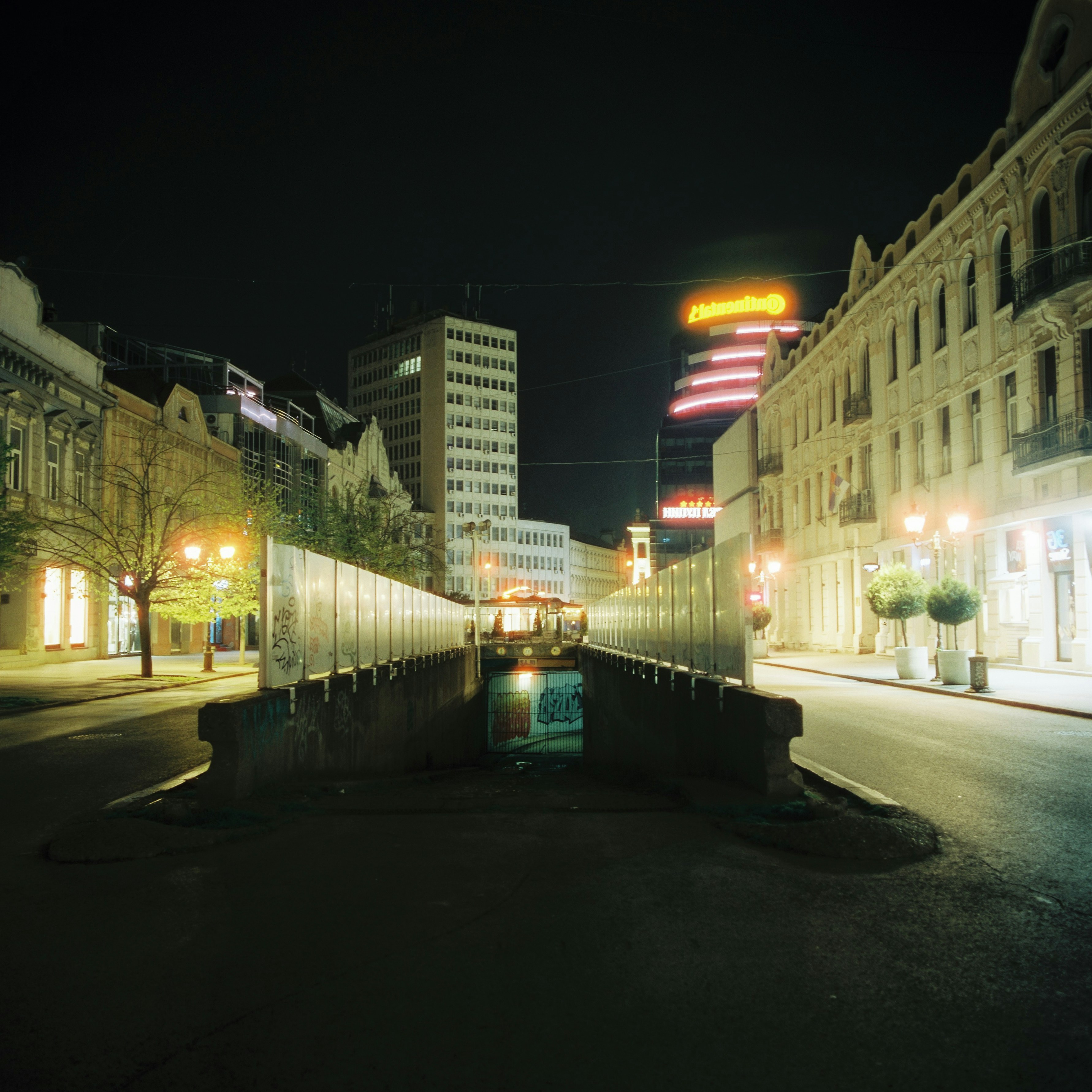 A city street at night with buildings lit up
