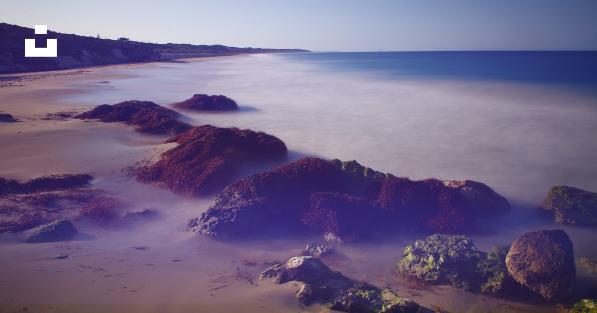 A view of a beach with rocks and water photo – Free Two rocks wa Image ...
