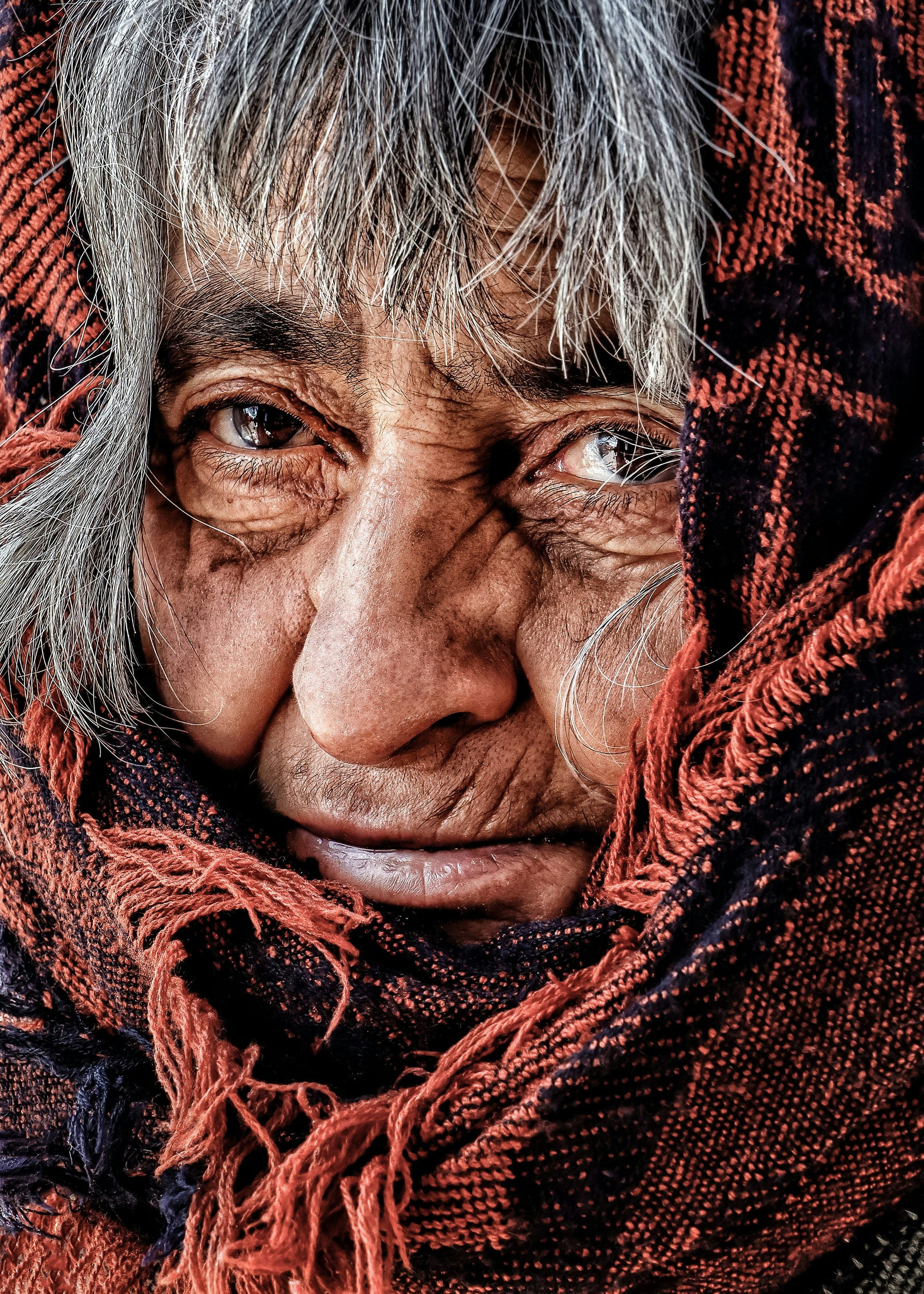 An old woman with a scarf around her neck