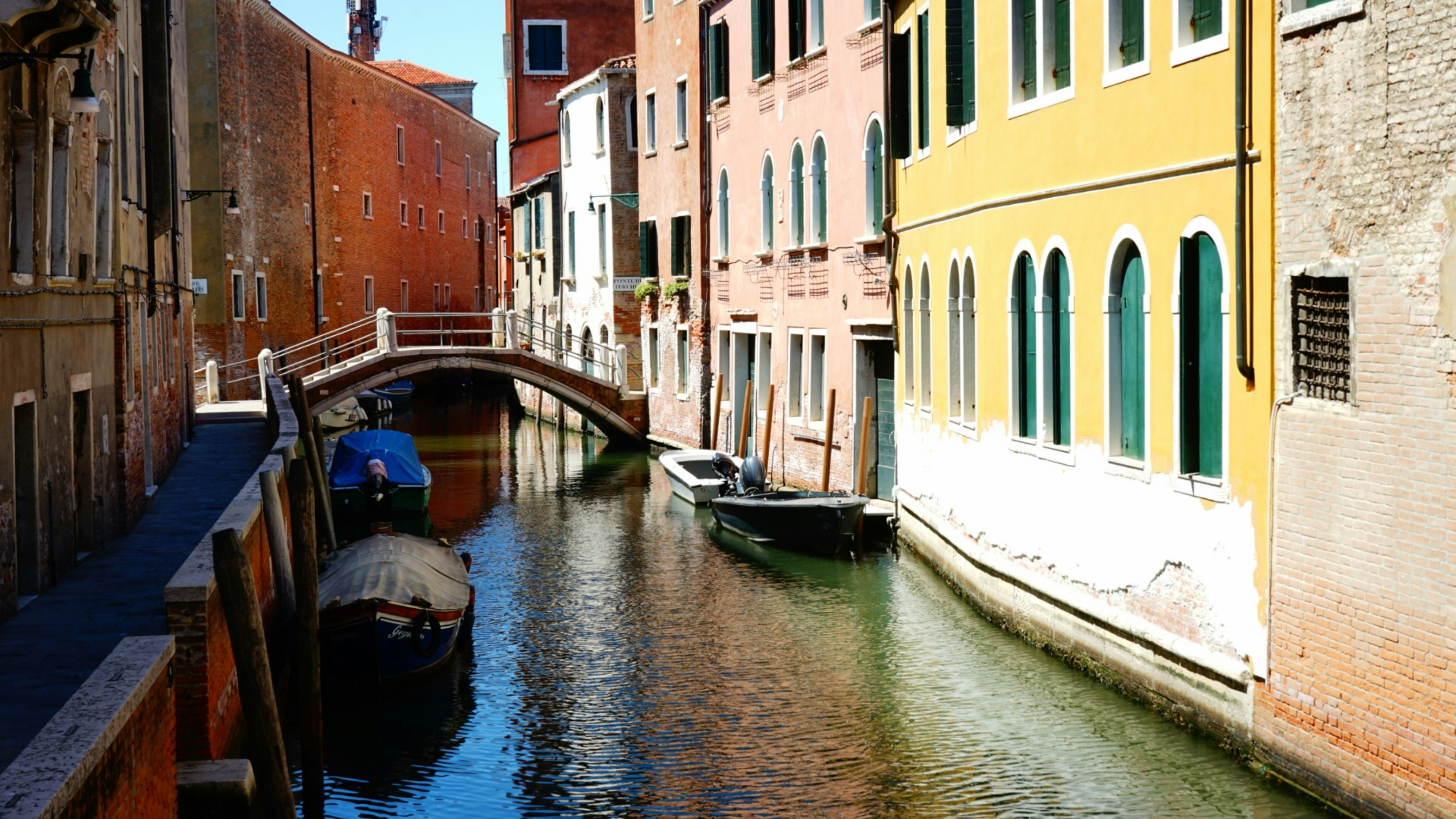 A canal running through a city next to tall buildings