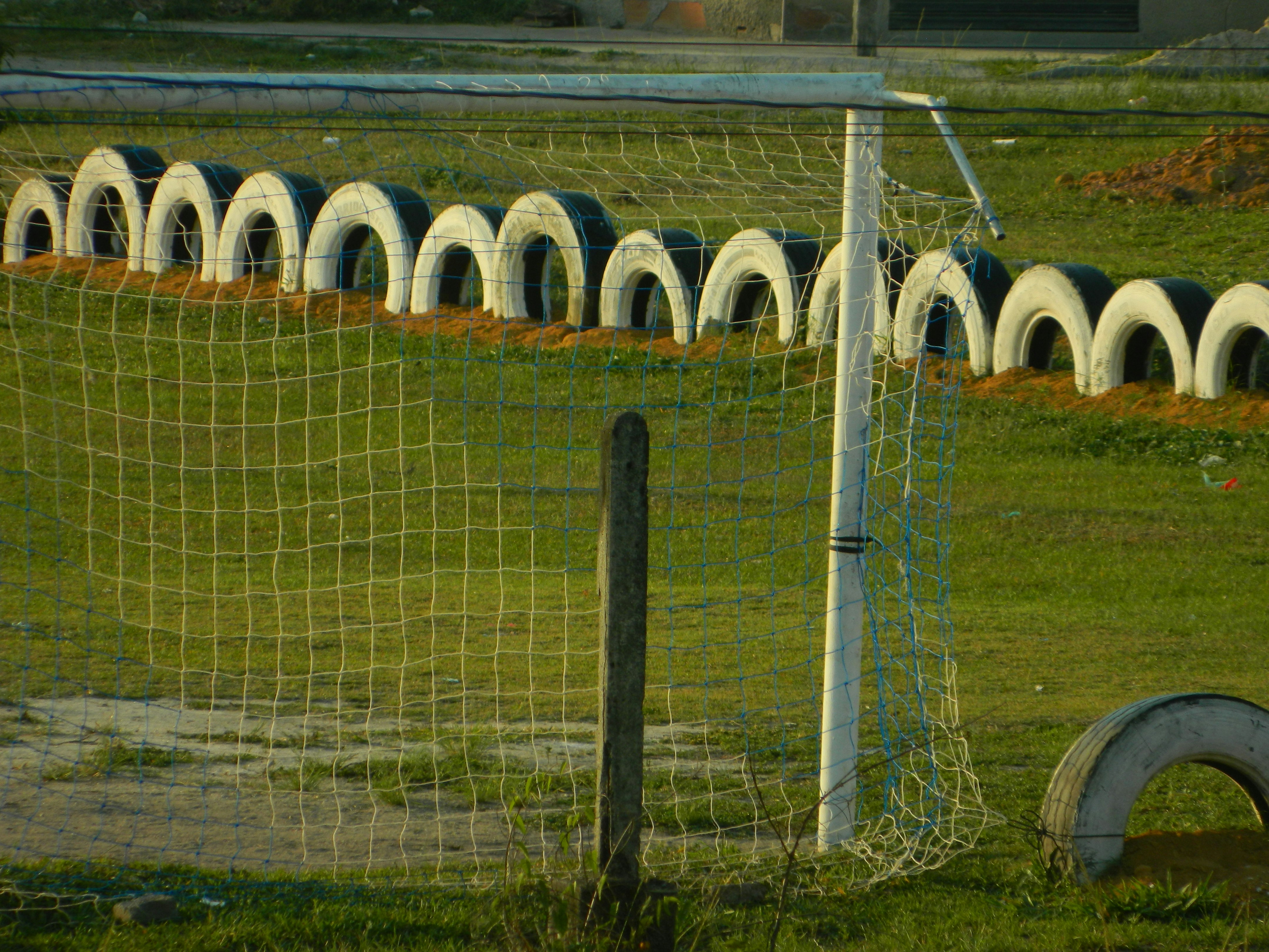 A soccer field with a soccer goal and a soccer ball