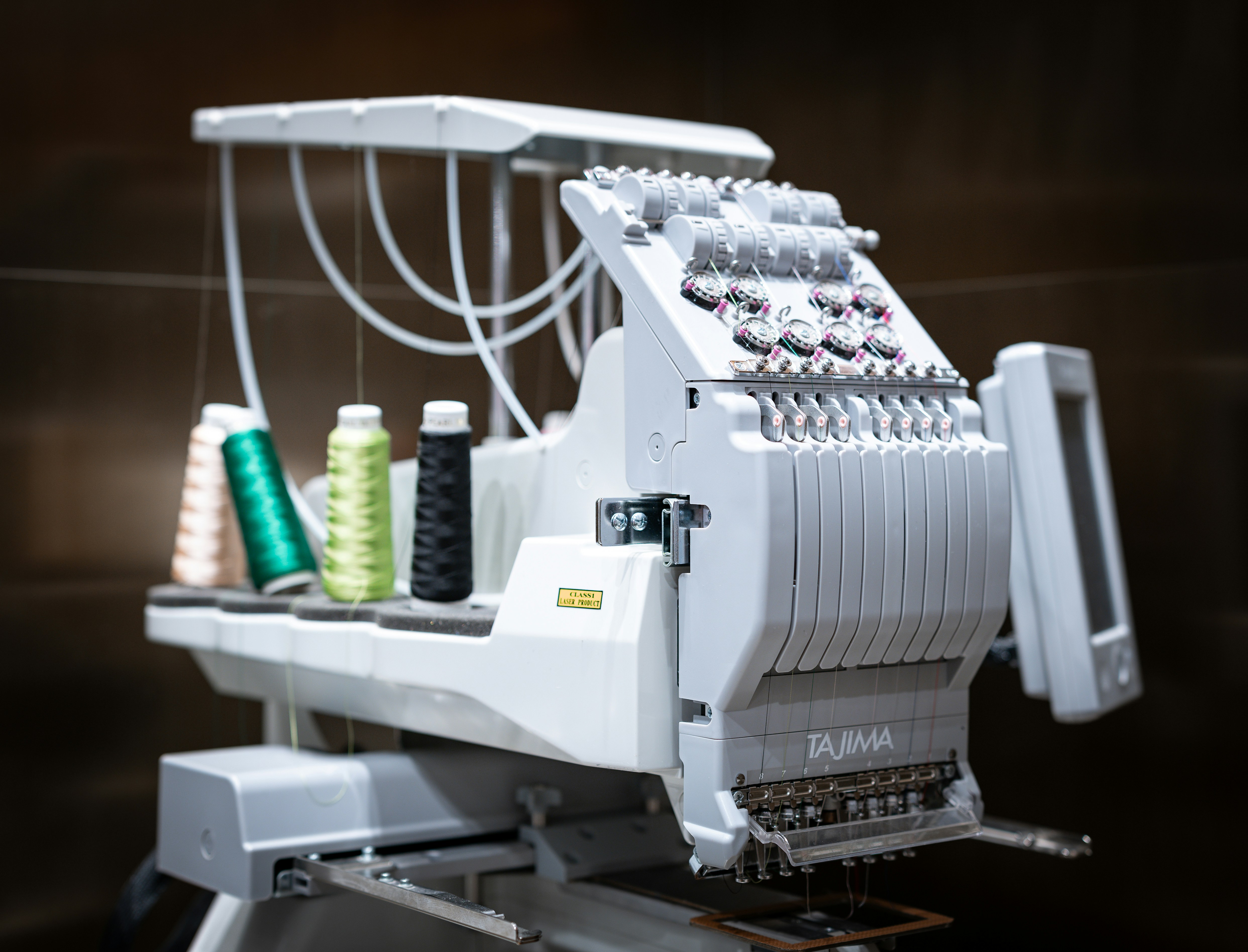 A close-up of a textile machine processing colorful fabrics in a factory setting.