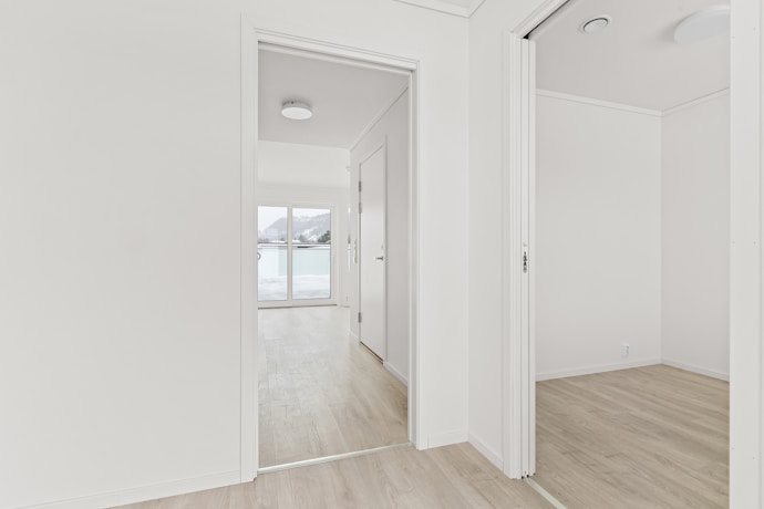 An empty room with white walls and wooden floors