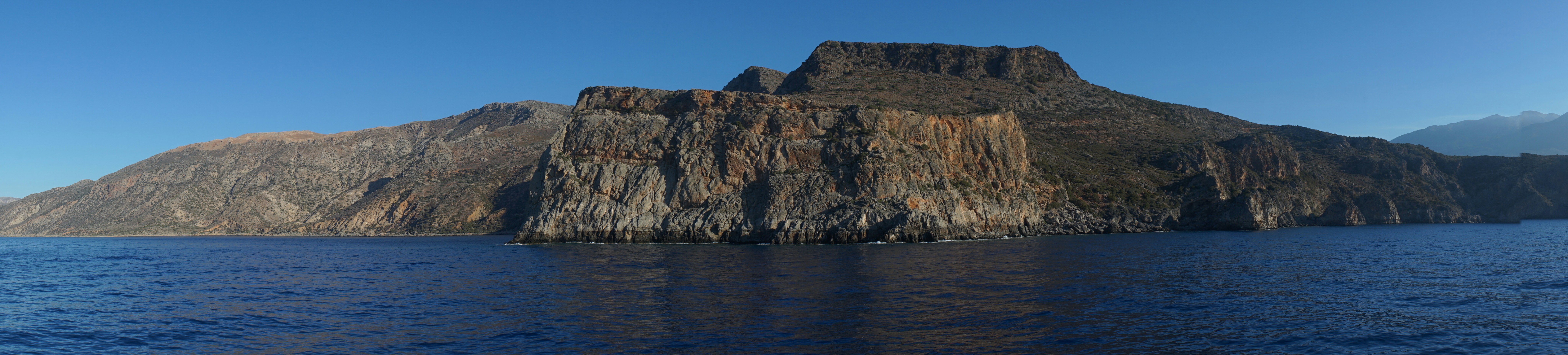 A large body of water with a mountain in the background