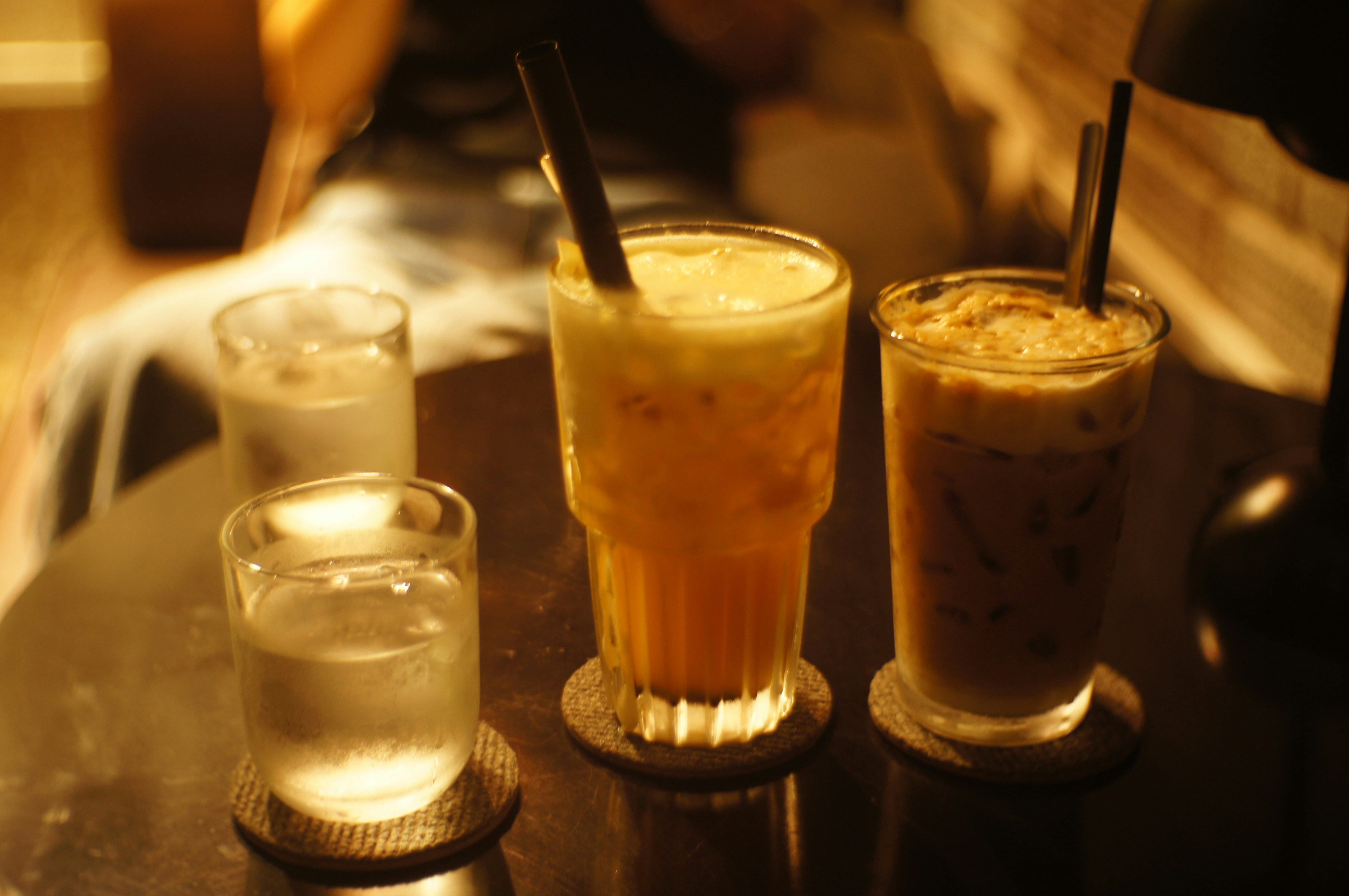 Assorted cold drinks including cola, water bottles and traditional ayran on dark background