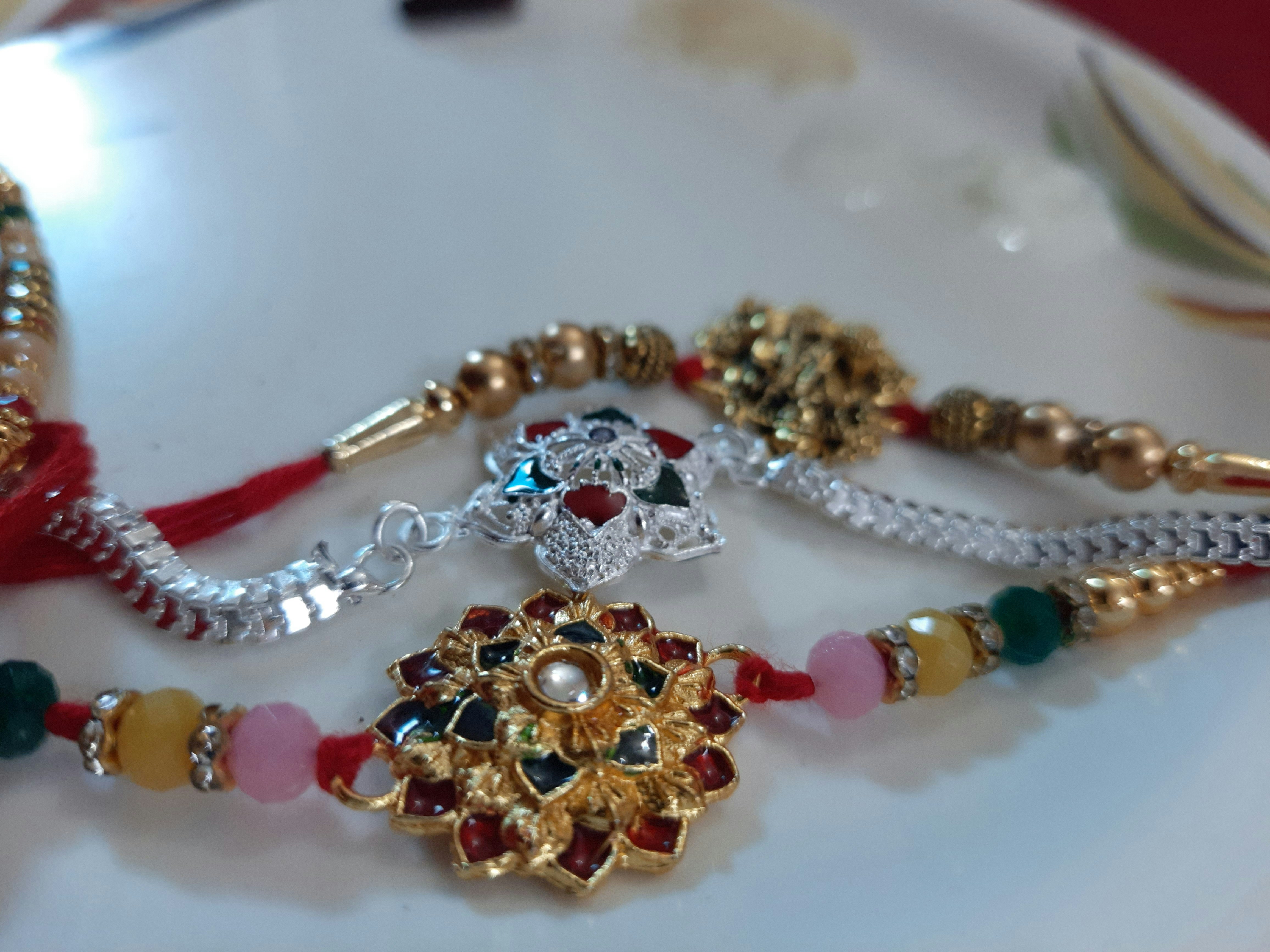 Silver rakhi with intricate floral design on festive background with marigold flowers