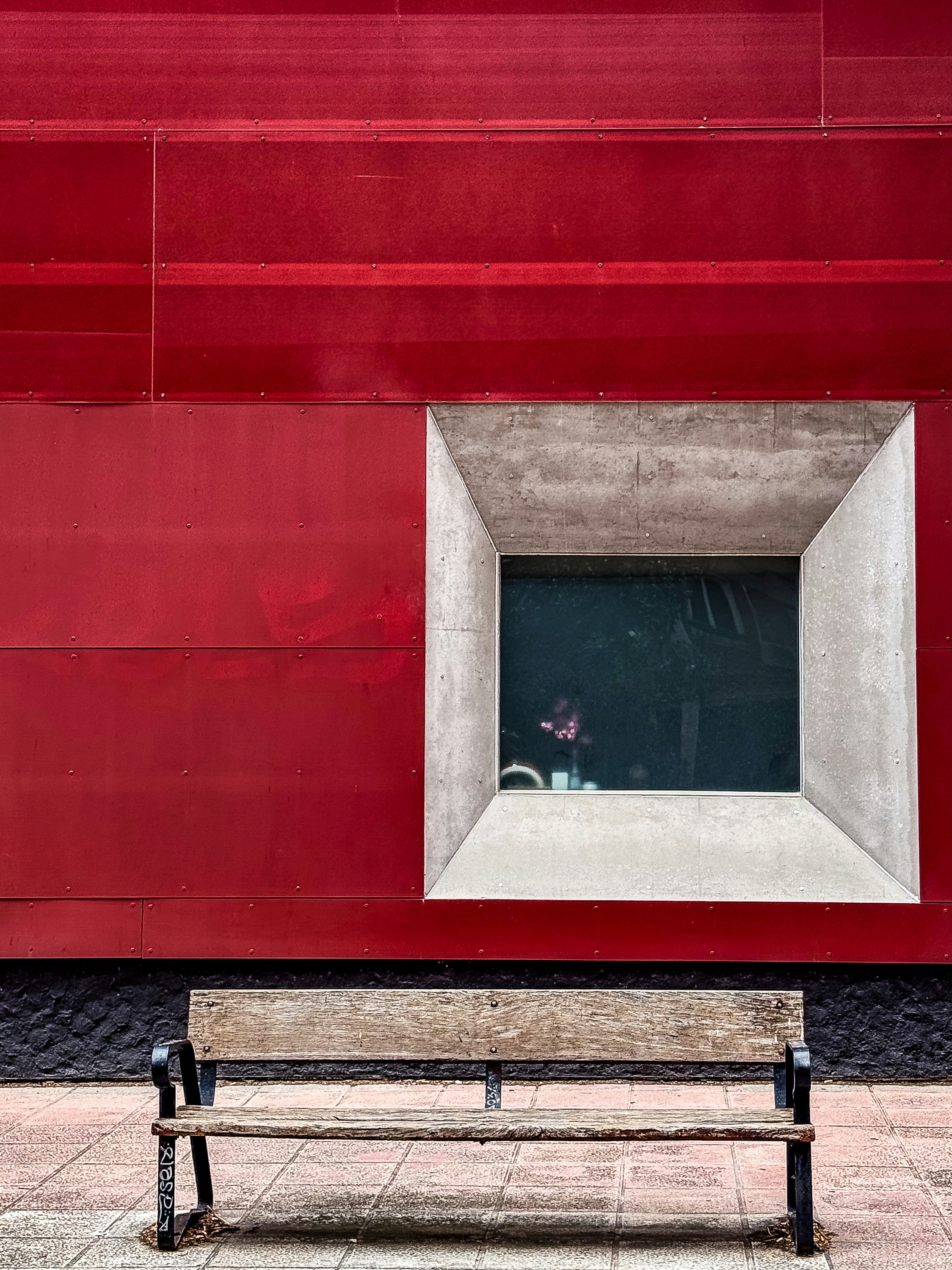 A bench sitting in front of a red building