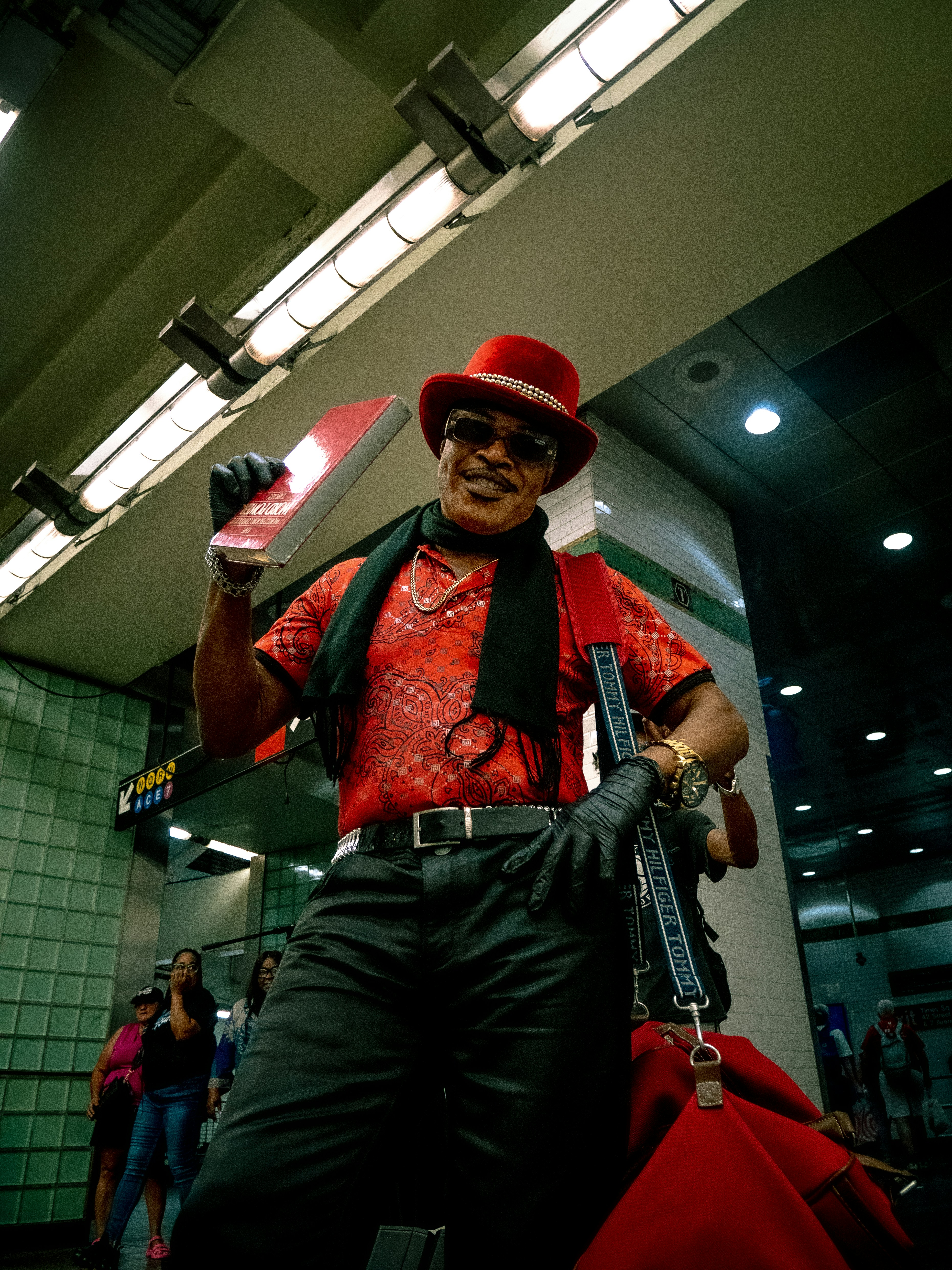 Seorang pria bertopi merah memegang pistol