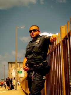A man in a police uniform standing on a bridge