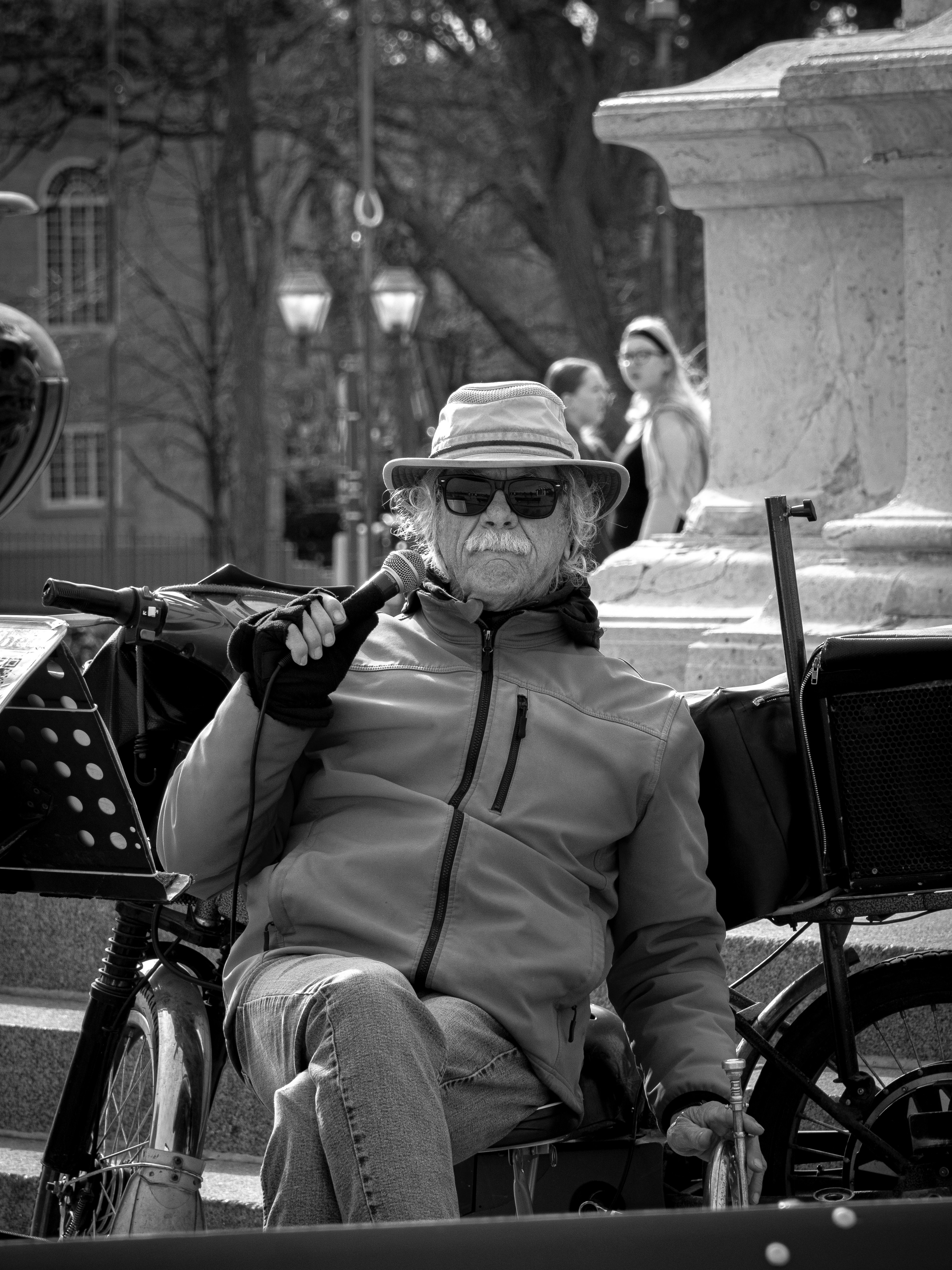 A man sitting on a bench next to a bike