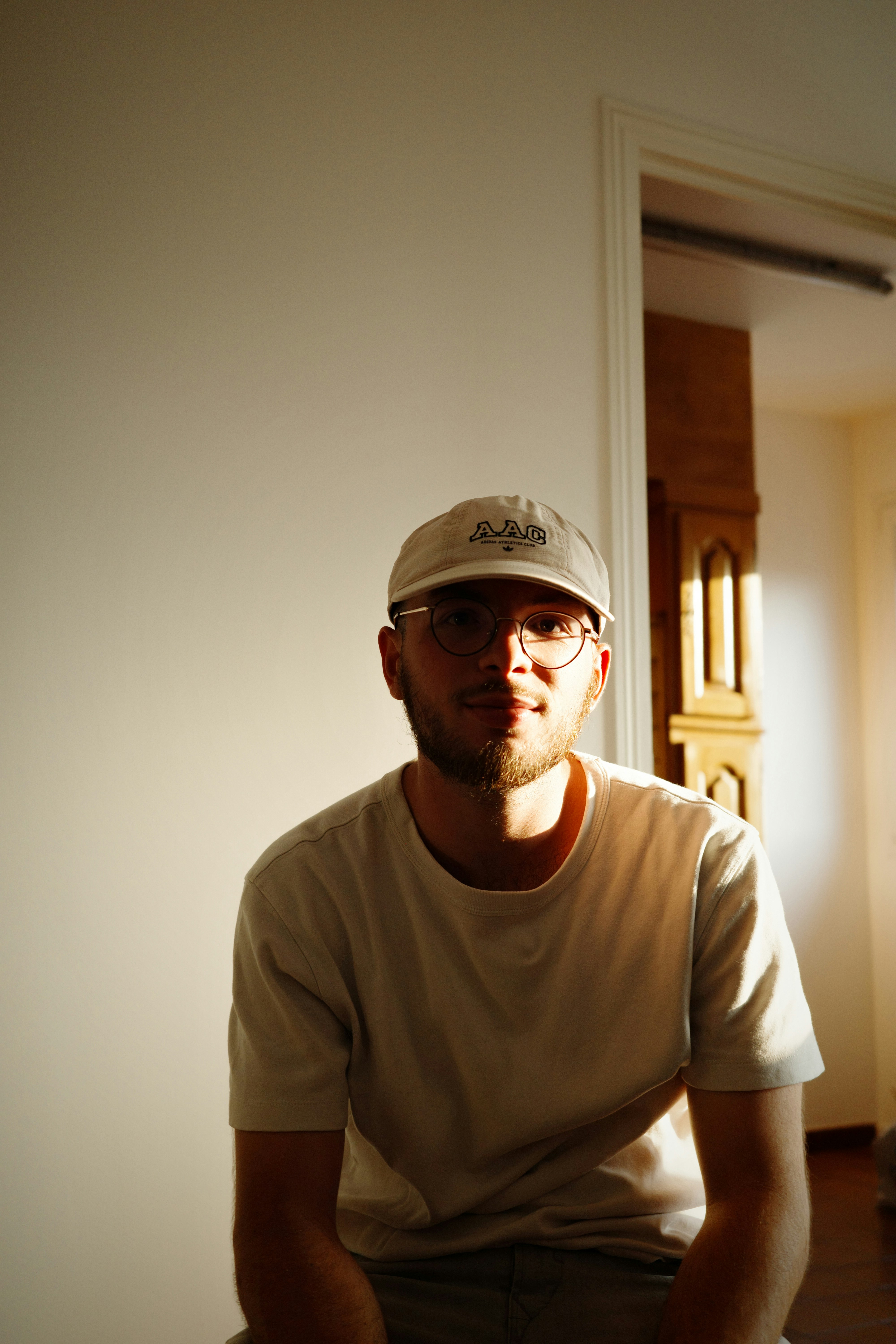 A man wearing a hat sitting in a room