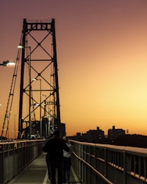 A couple of people walking across a bridge