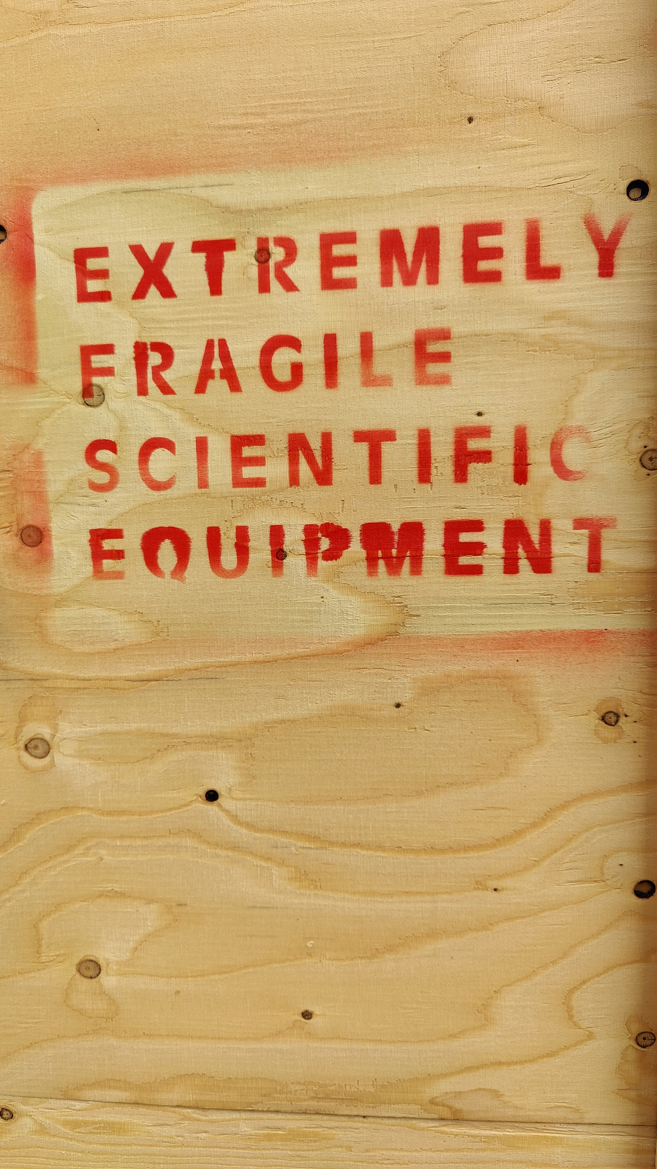 Close-up of a sign on a wooden wall