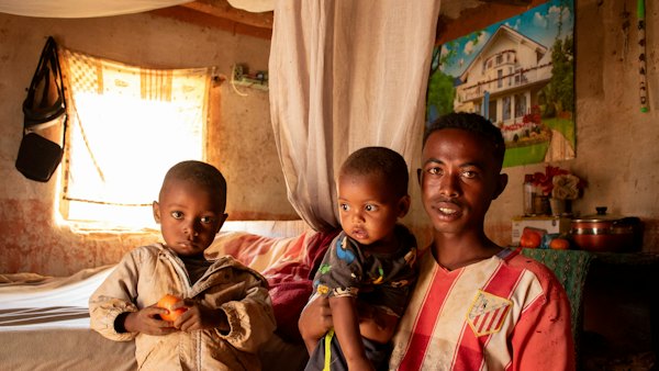 A man and two children standing in a bedroom — Madagascar, Madagascar